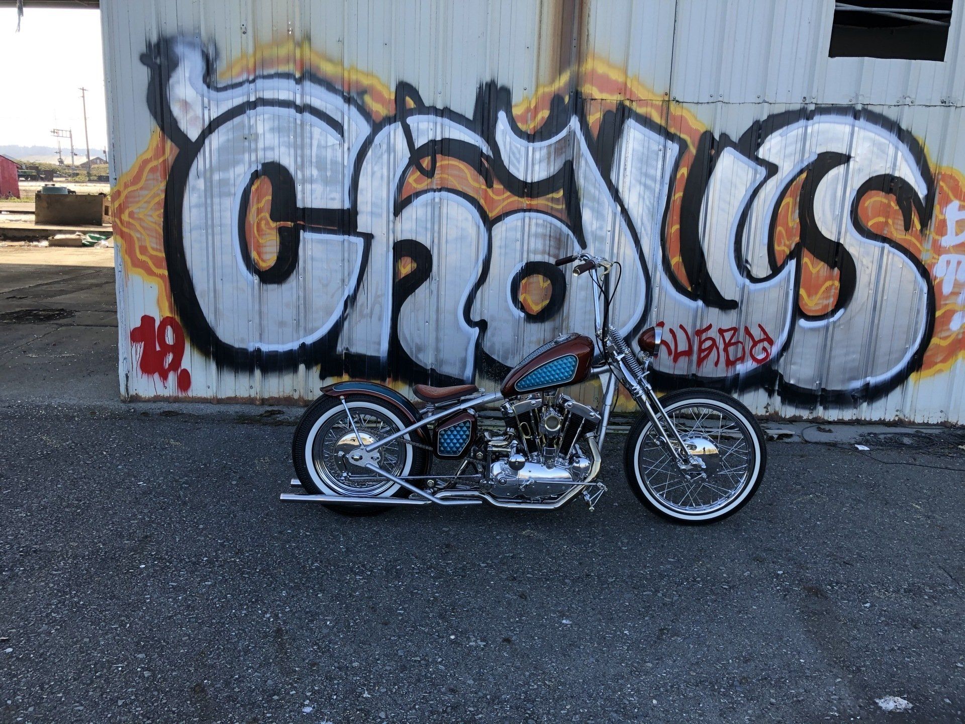 A motorcycle is parked in front of a building with graffiti on it
