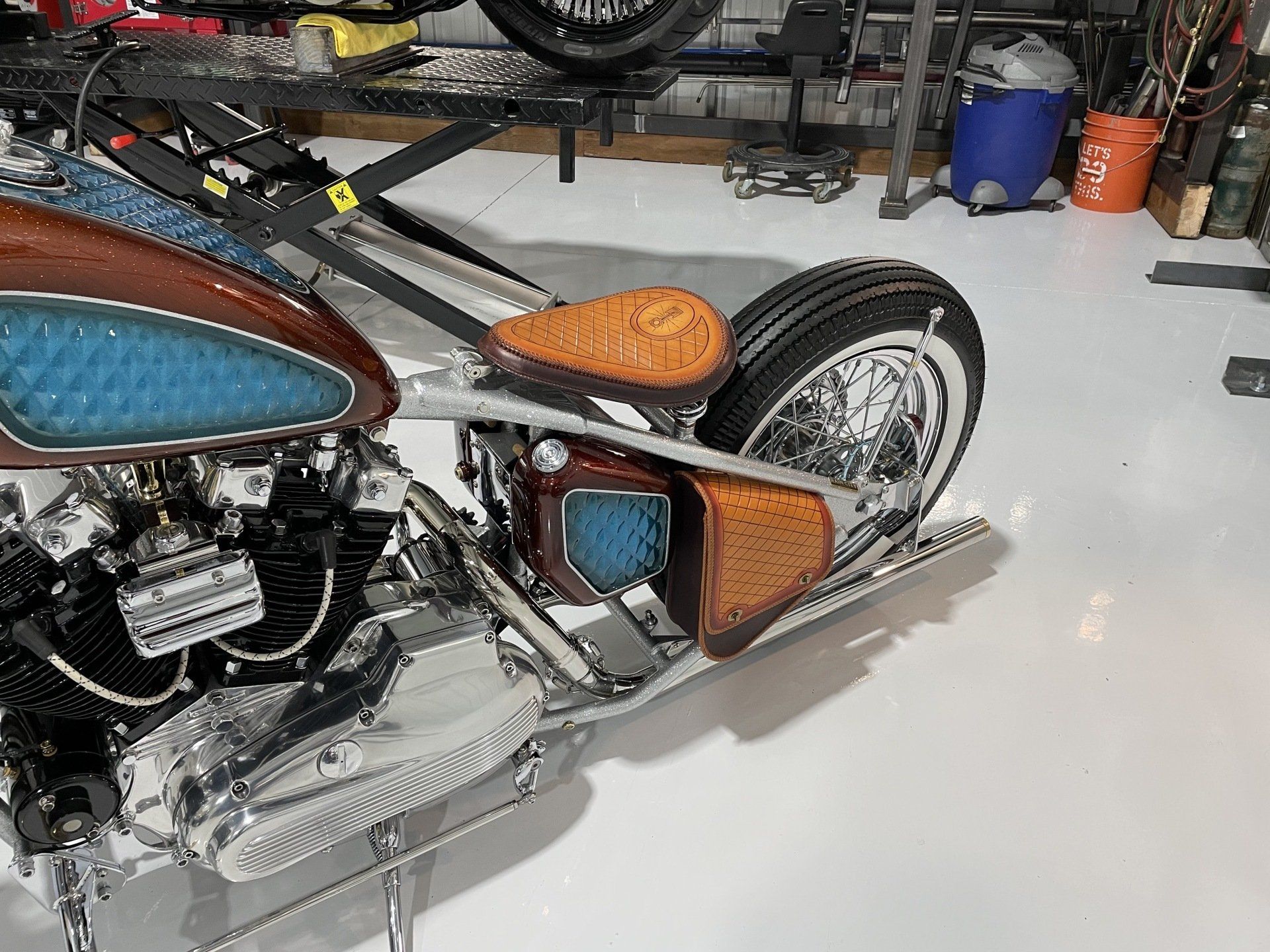 A motorcycle is parked on a white floor in a garage.