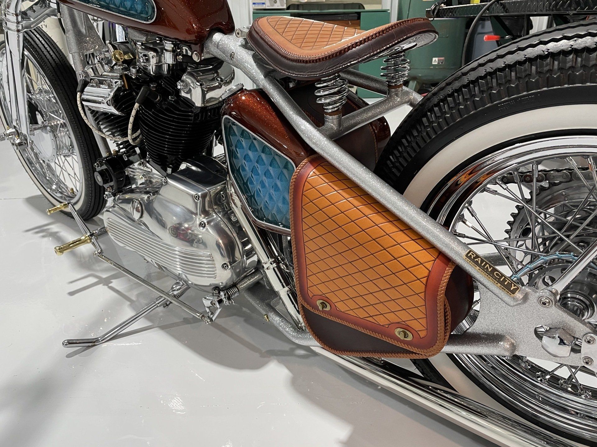 A close up of a motorcycle with a leather bag attached to it