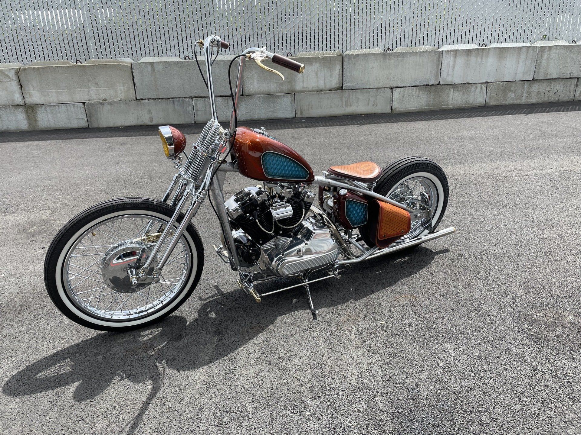 A chopper motorcycle is parked on the side of the road.
