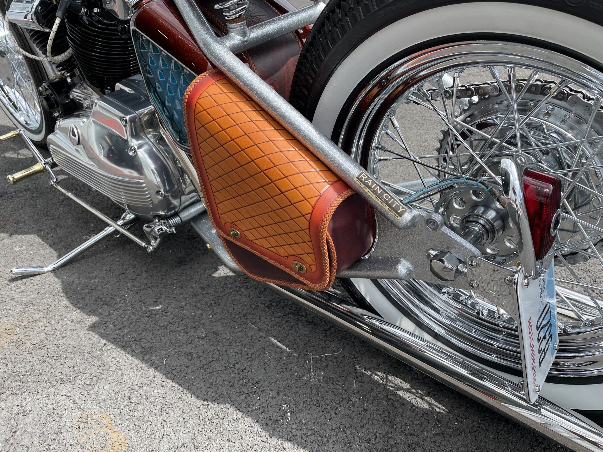 A brown leather bag is attached to the side of a motorcycle