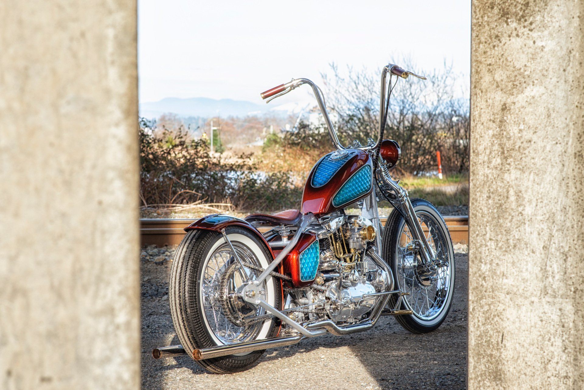 A chopper motorcycle is parked on the side of the road.