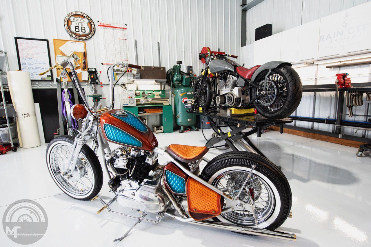 Two motorcycles are parked next to each other in a garage.