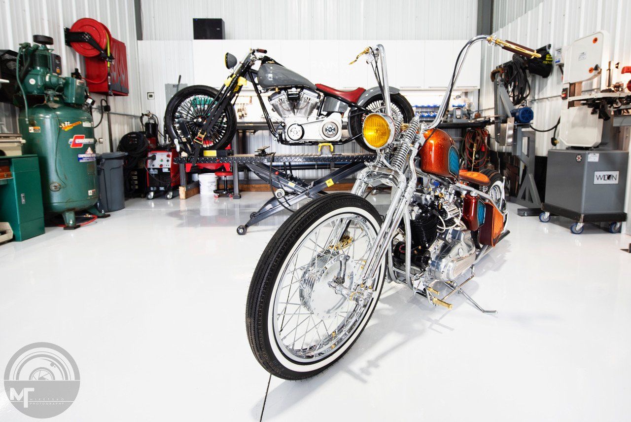 A motorcycle is parked in a garage with other motorcycles.