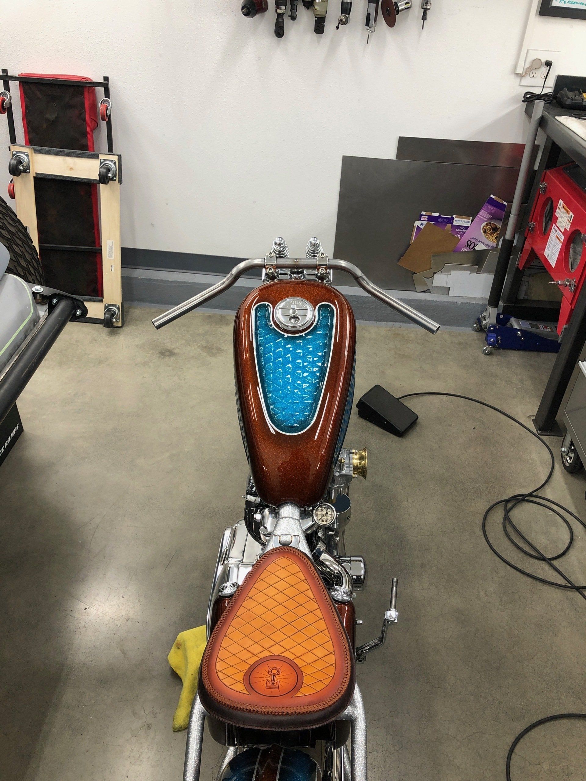 A brown and blue motorcycle is parked in a garage