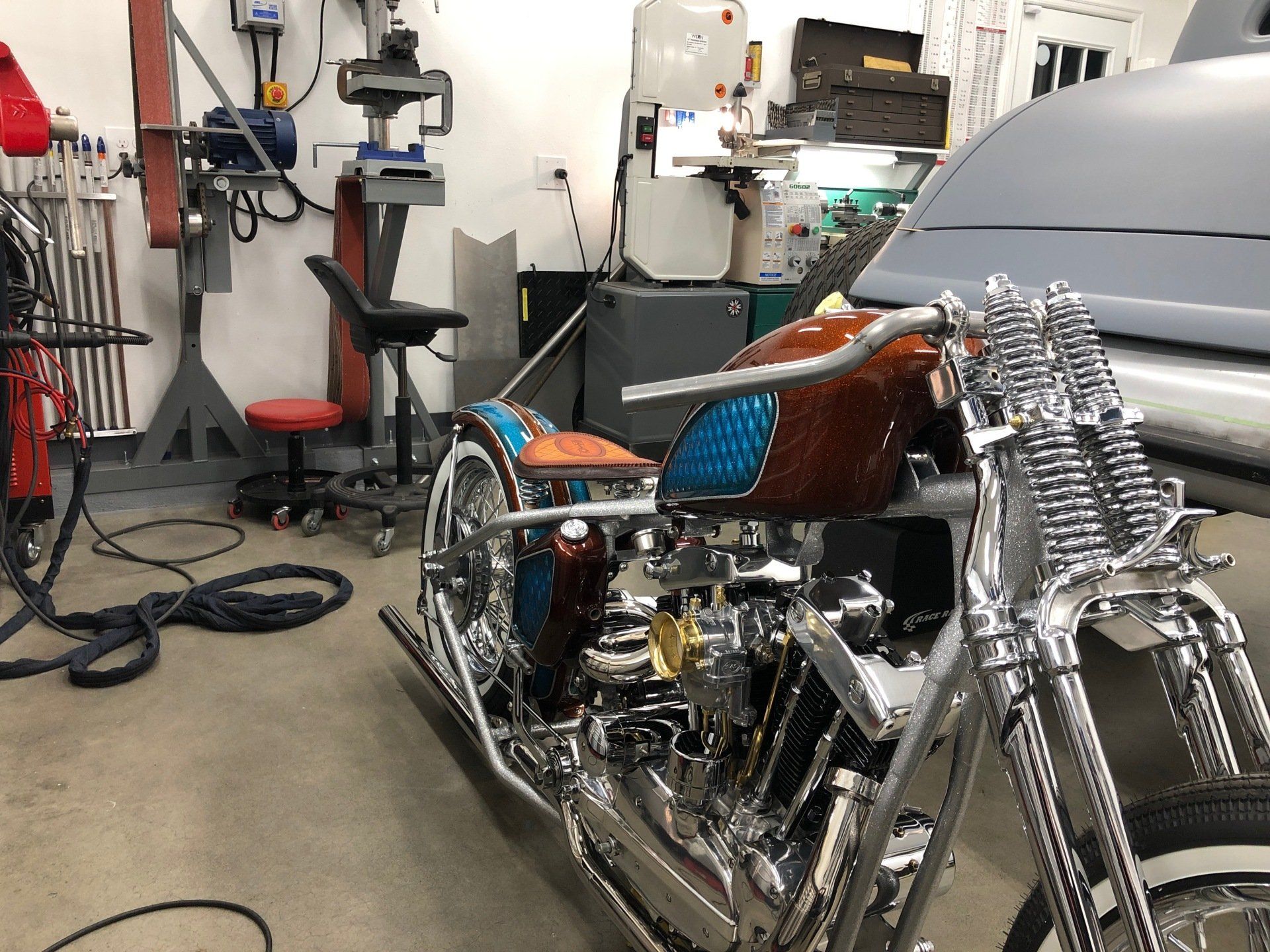 A motorcycle is parked in a garage next to a car.