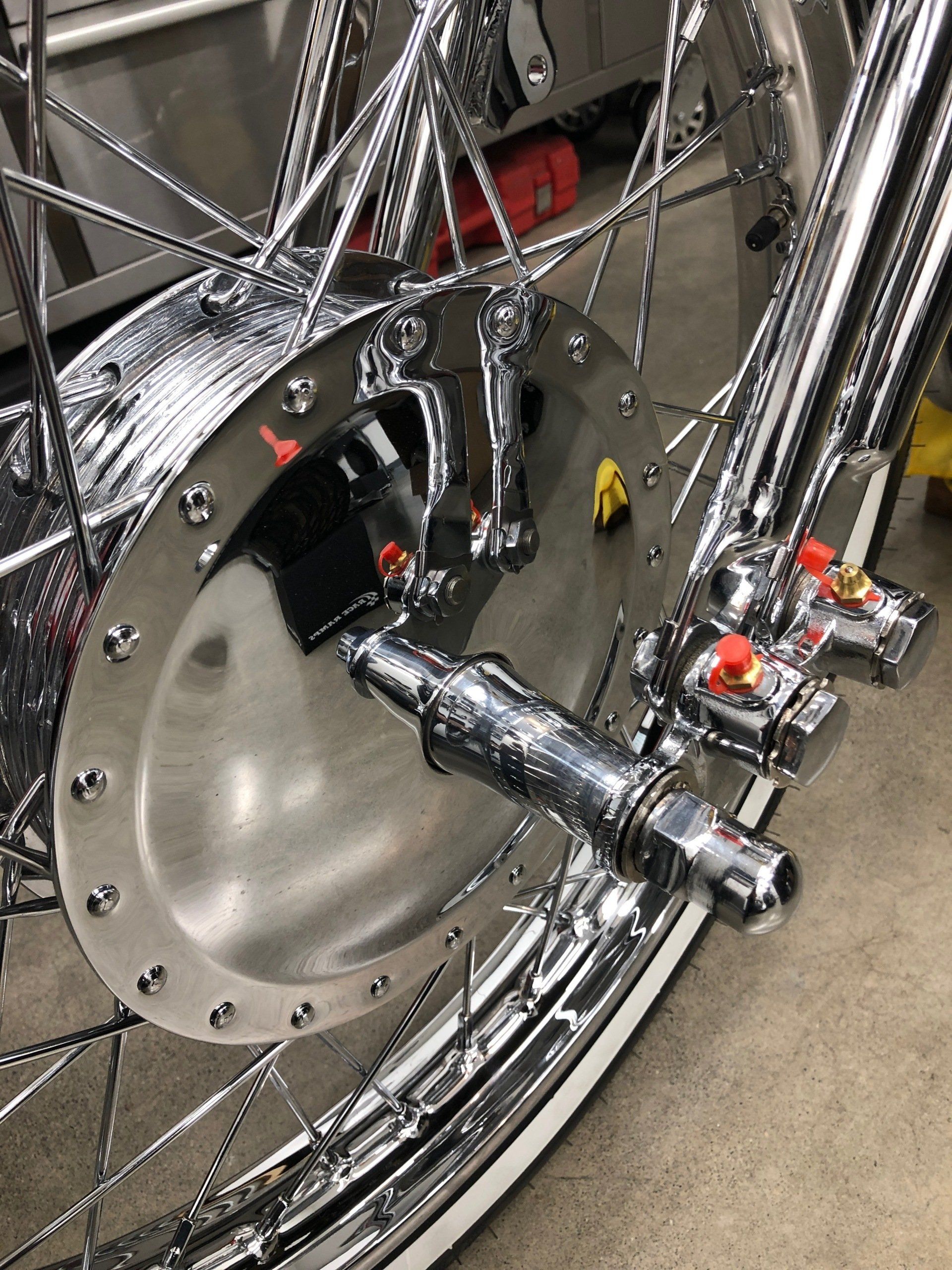 A close up of a motorcycle wheel in a garage.
