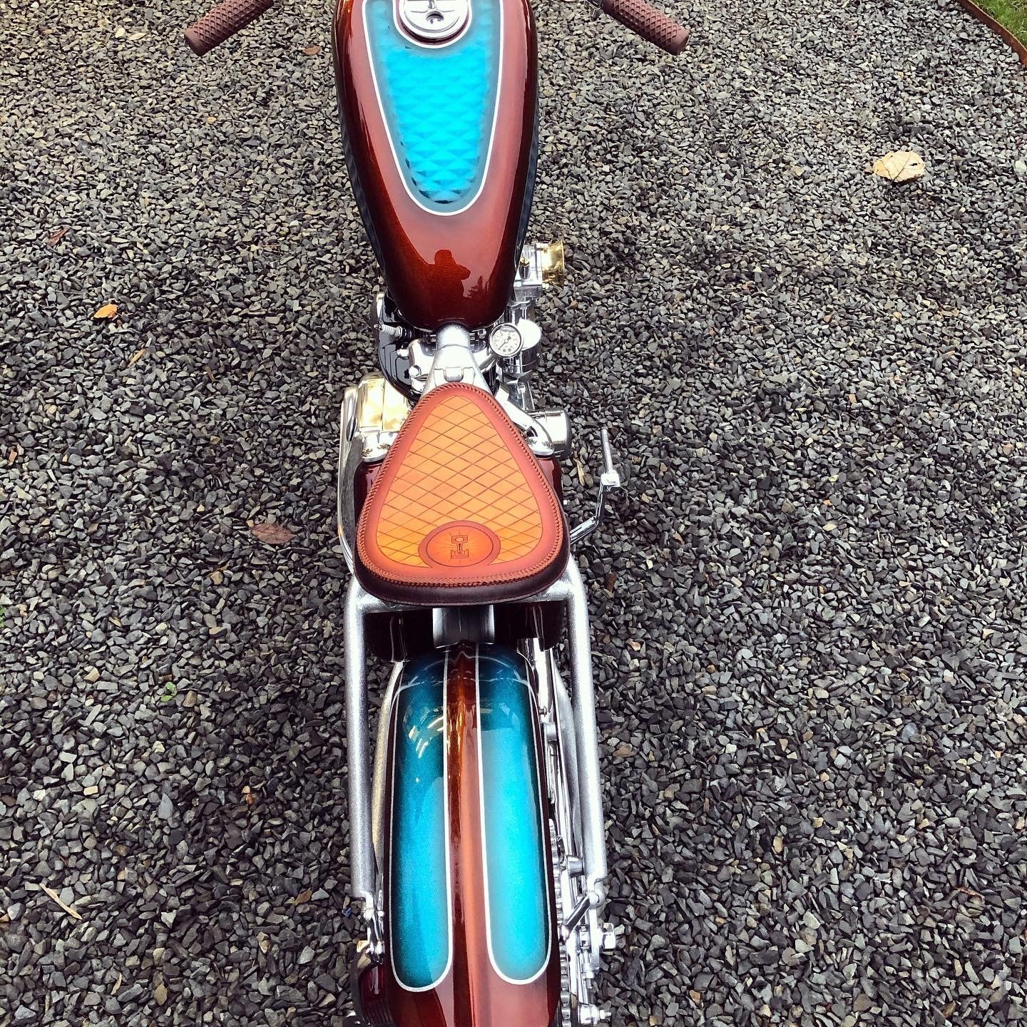 A motorcycle is parked on a gravel road.
