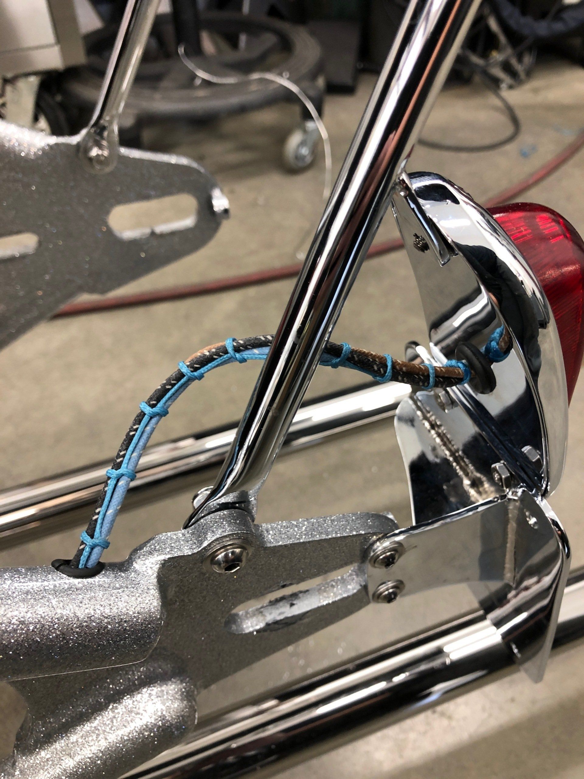 A close up of a metal object with a blue cable attached to it.