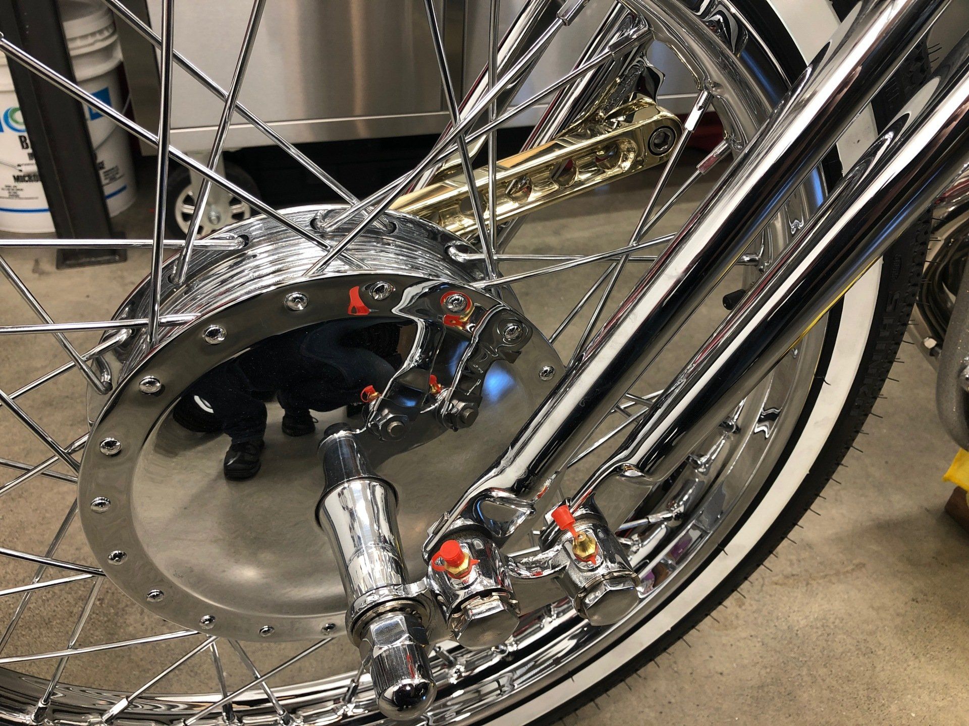 A close up of a motorcycle wheel with a saxophone in the background