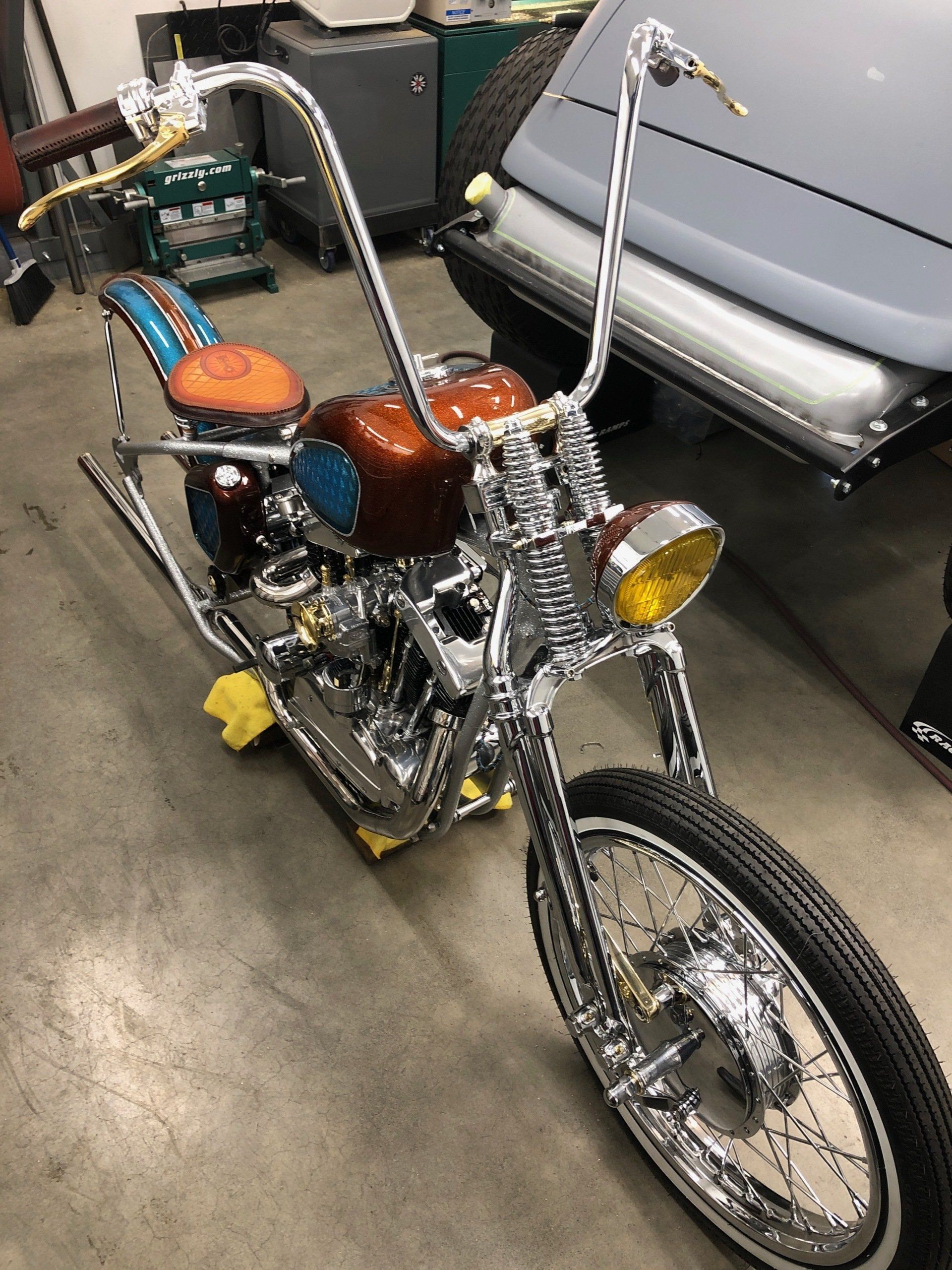A motorcycle is parked in a garage next to a car.