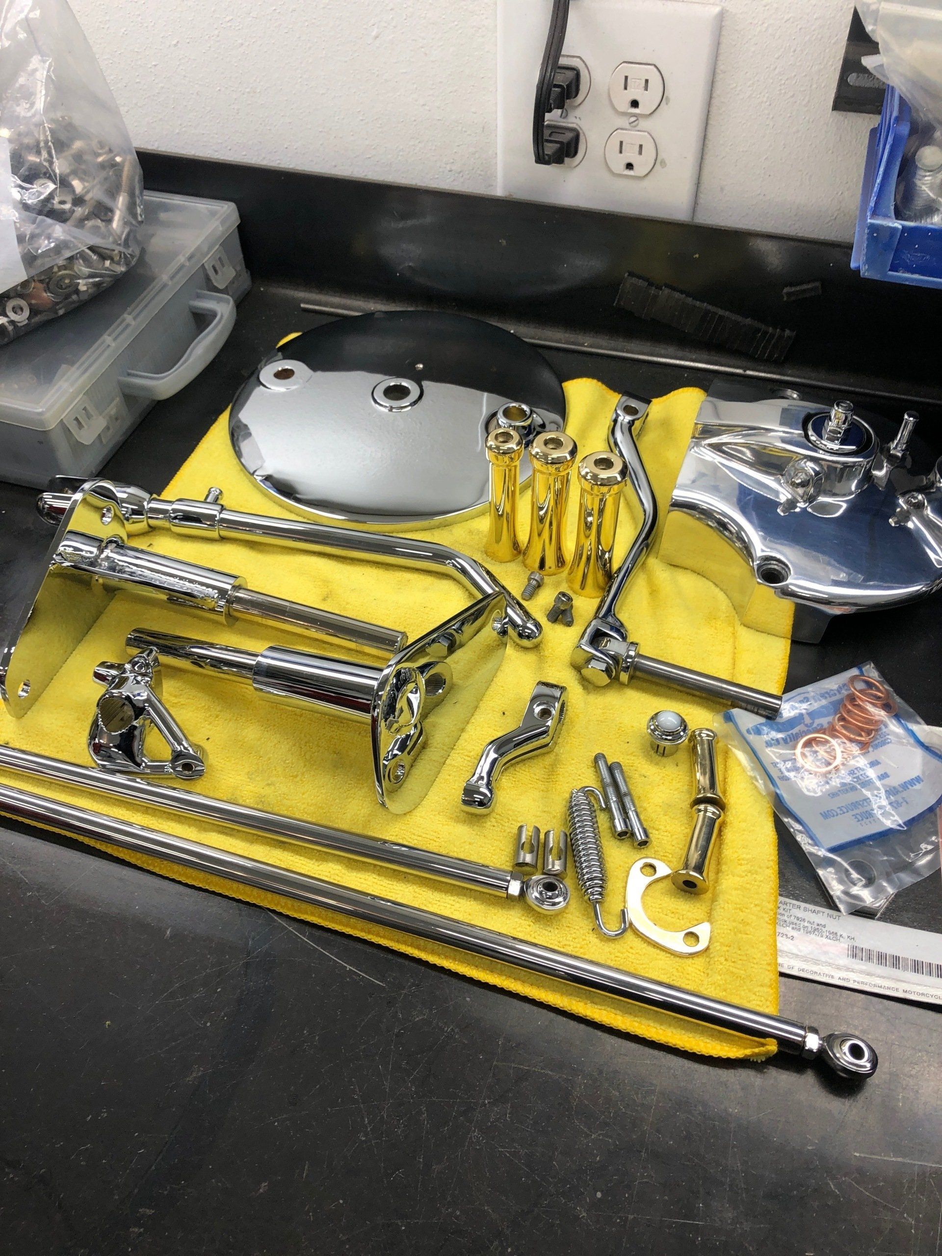 A bunch of chrome parts on a yellow towel on a counter