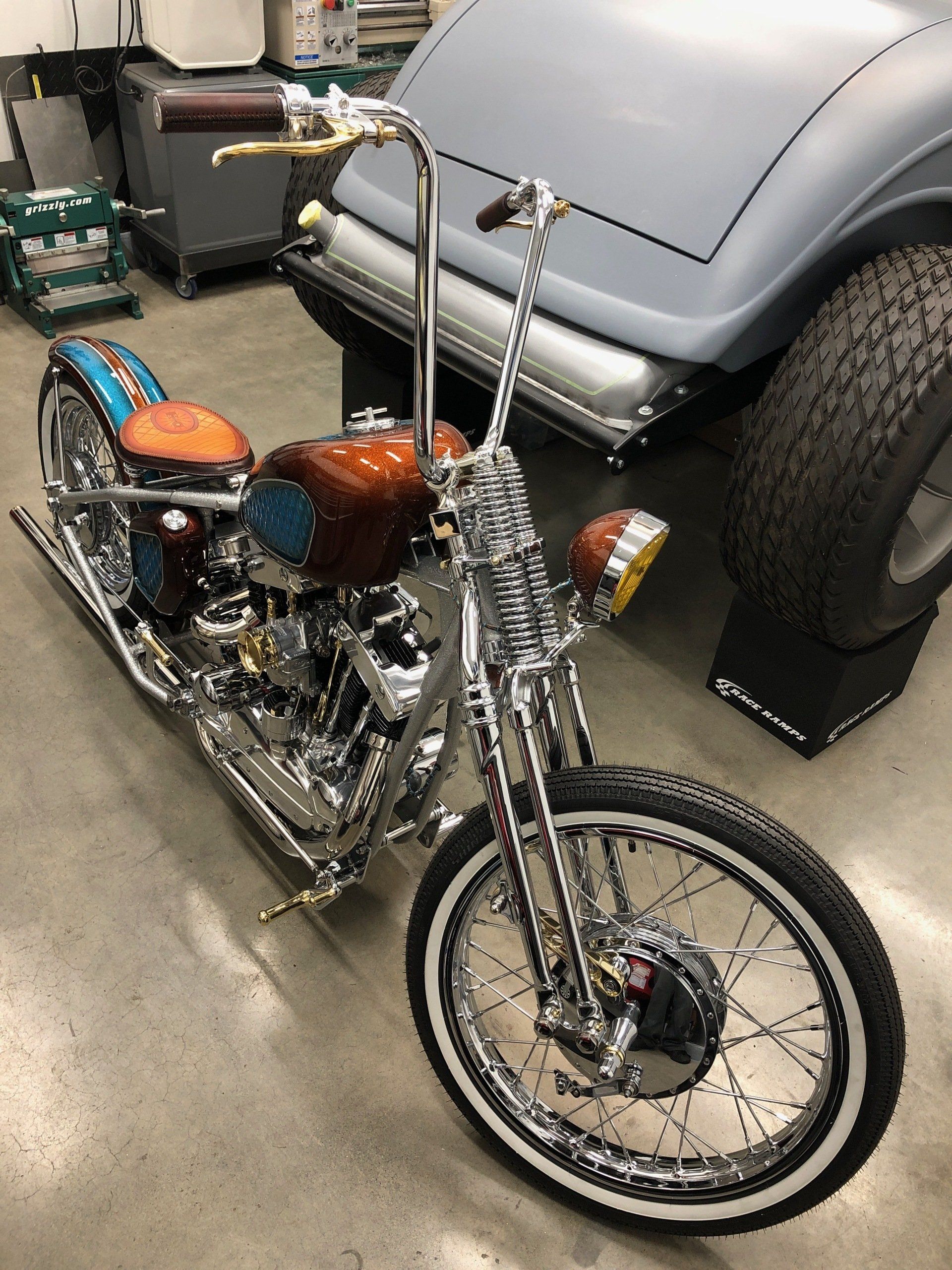 A motorcycle is parked in a garage next to a car