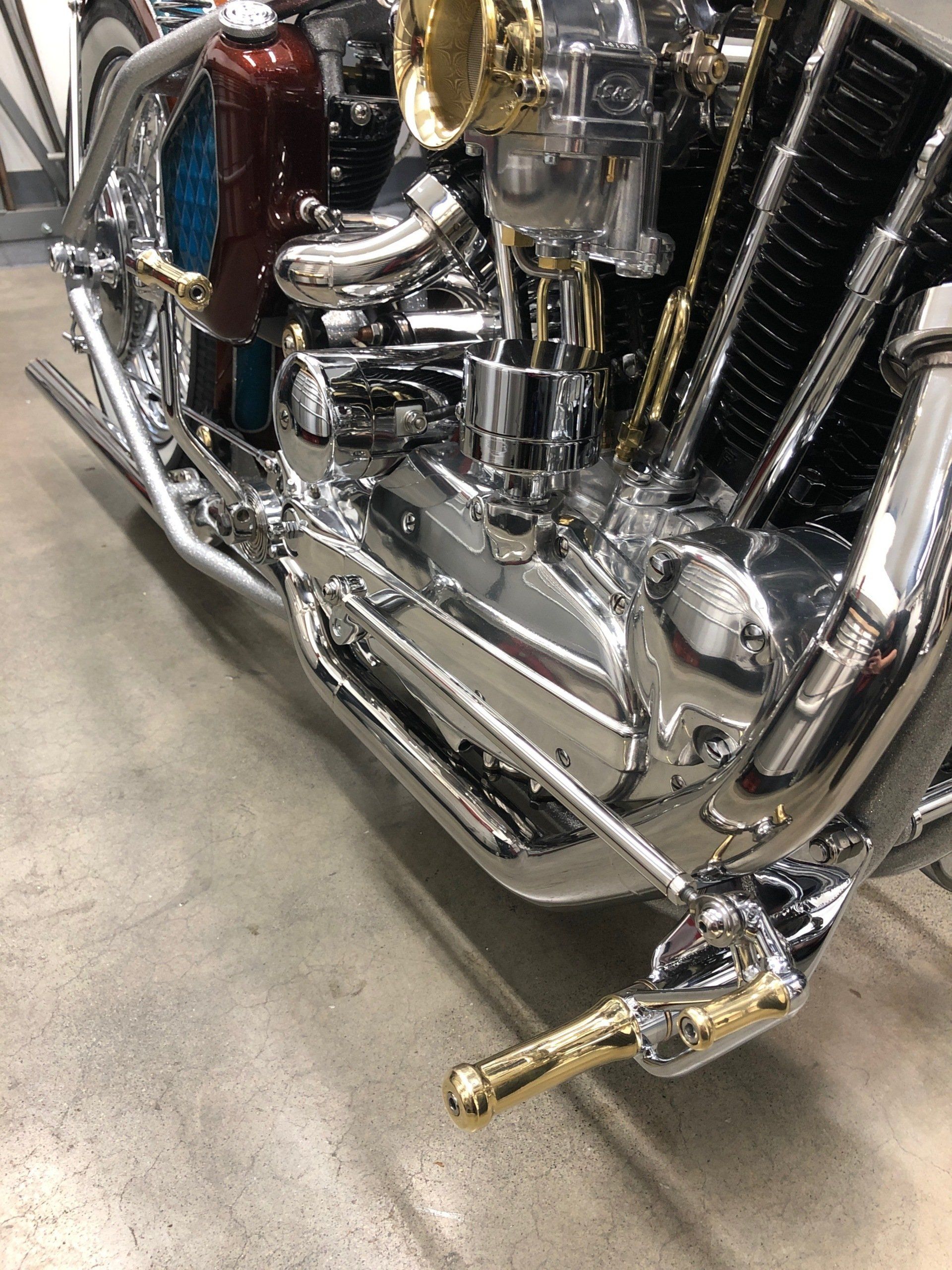 A close up of a motorcycle engine on a concrete floor.