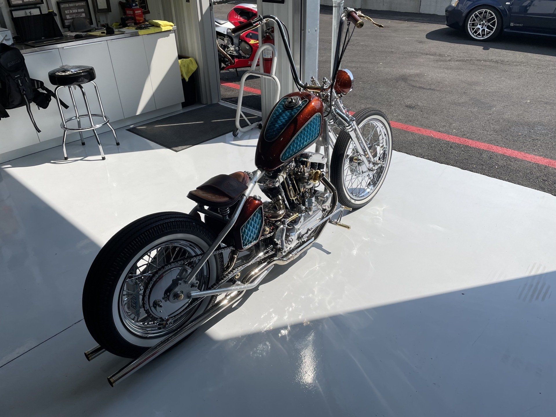 A motorcycle is parked on a white floor in a garage.