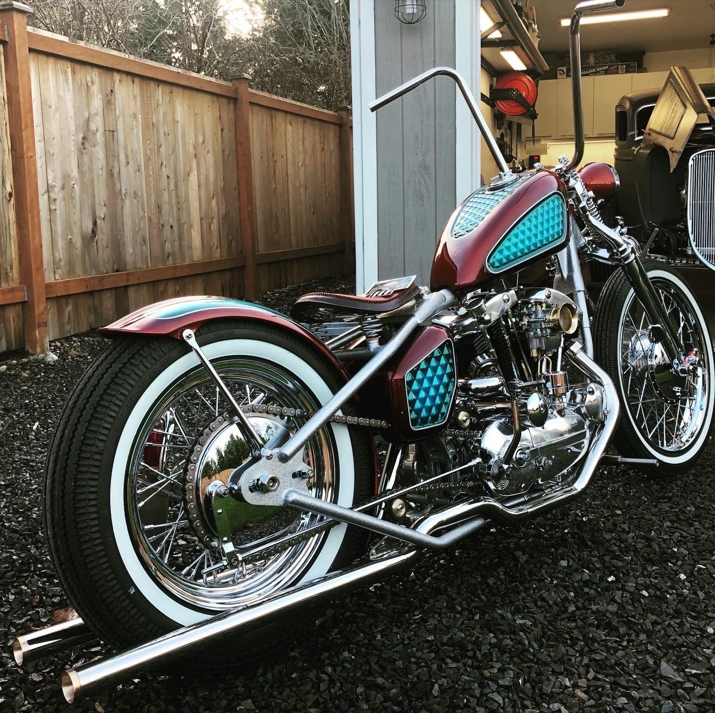 A red and blue motorcycle is parked in front of a garage