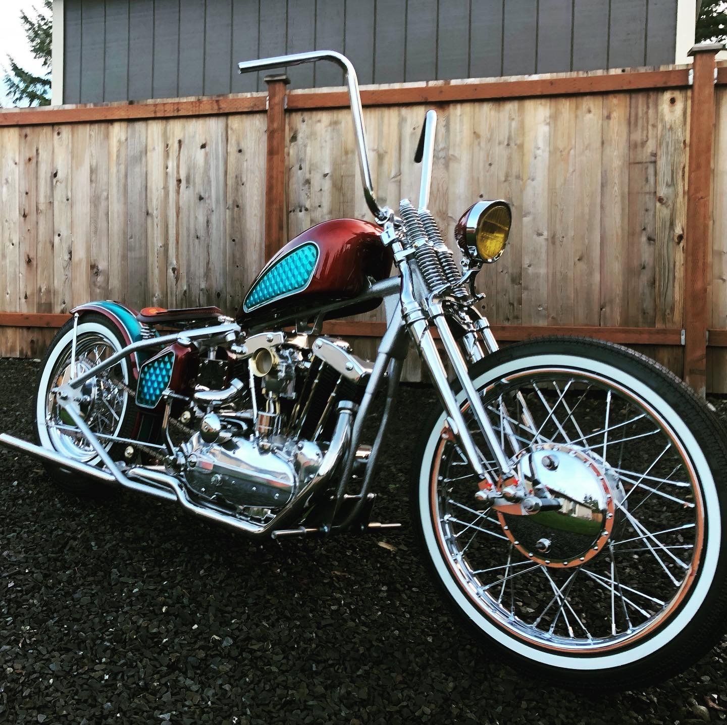 A motorcycle is parked in front of a wooden fence