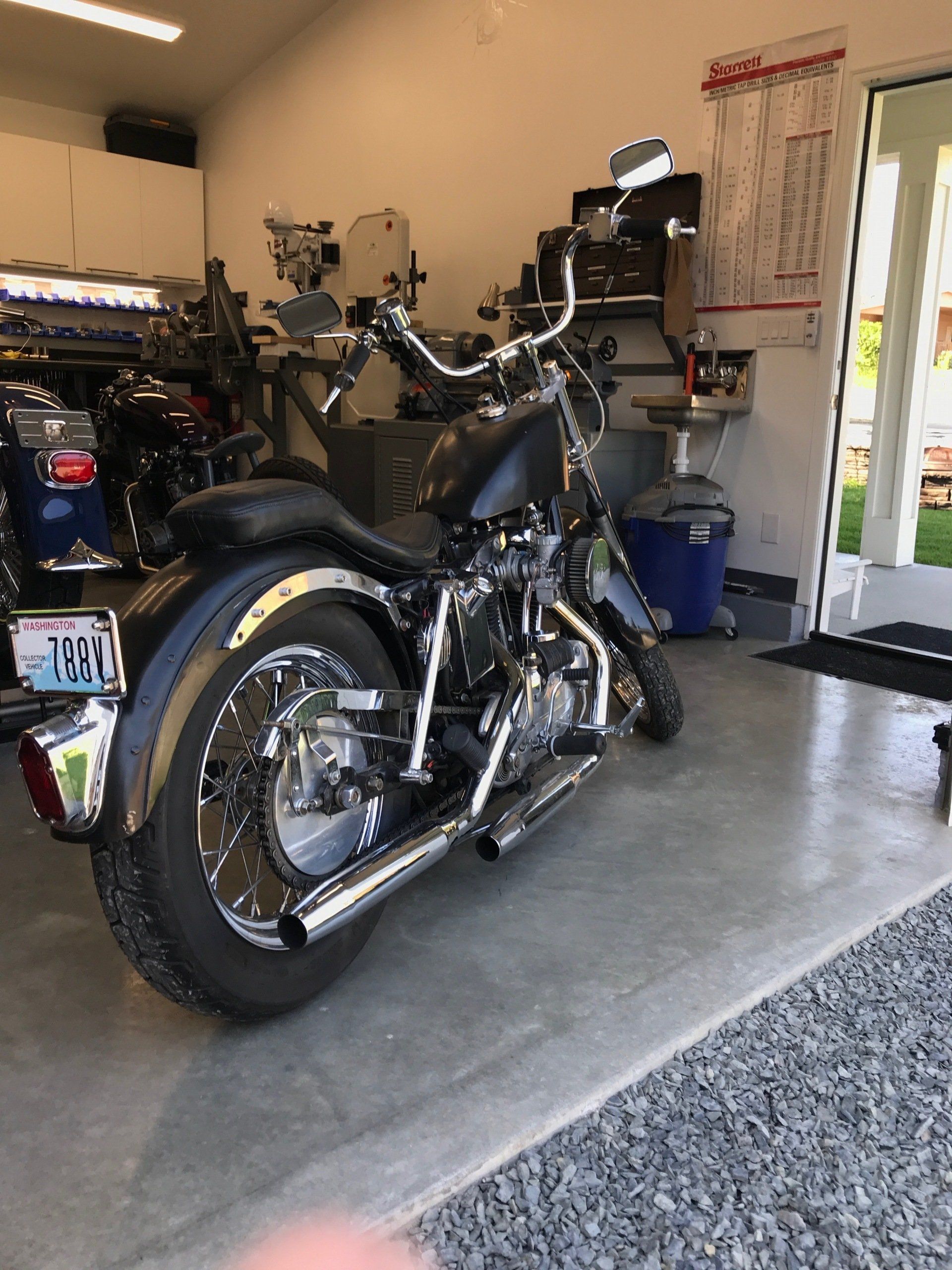 A black motorcycle is parked in a garage.