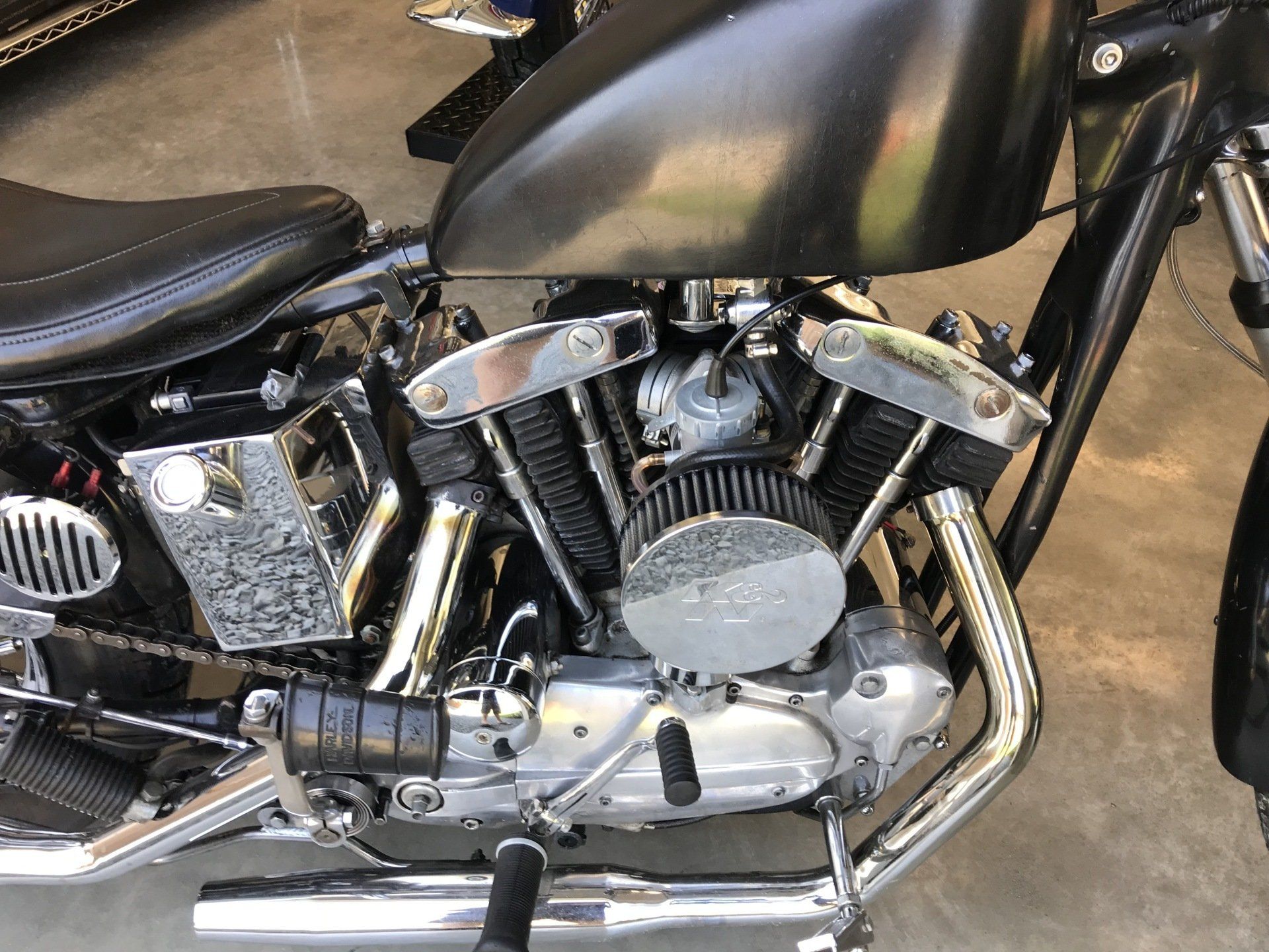 A close up of a motorcycle engine on a concrete surface.