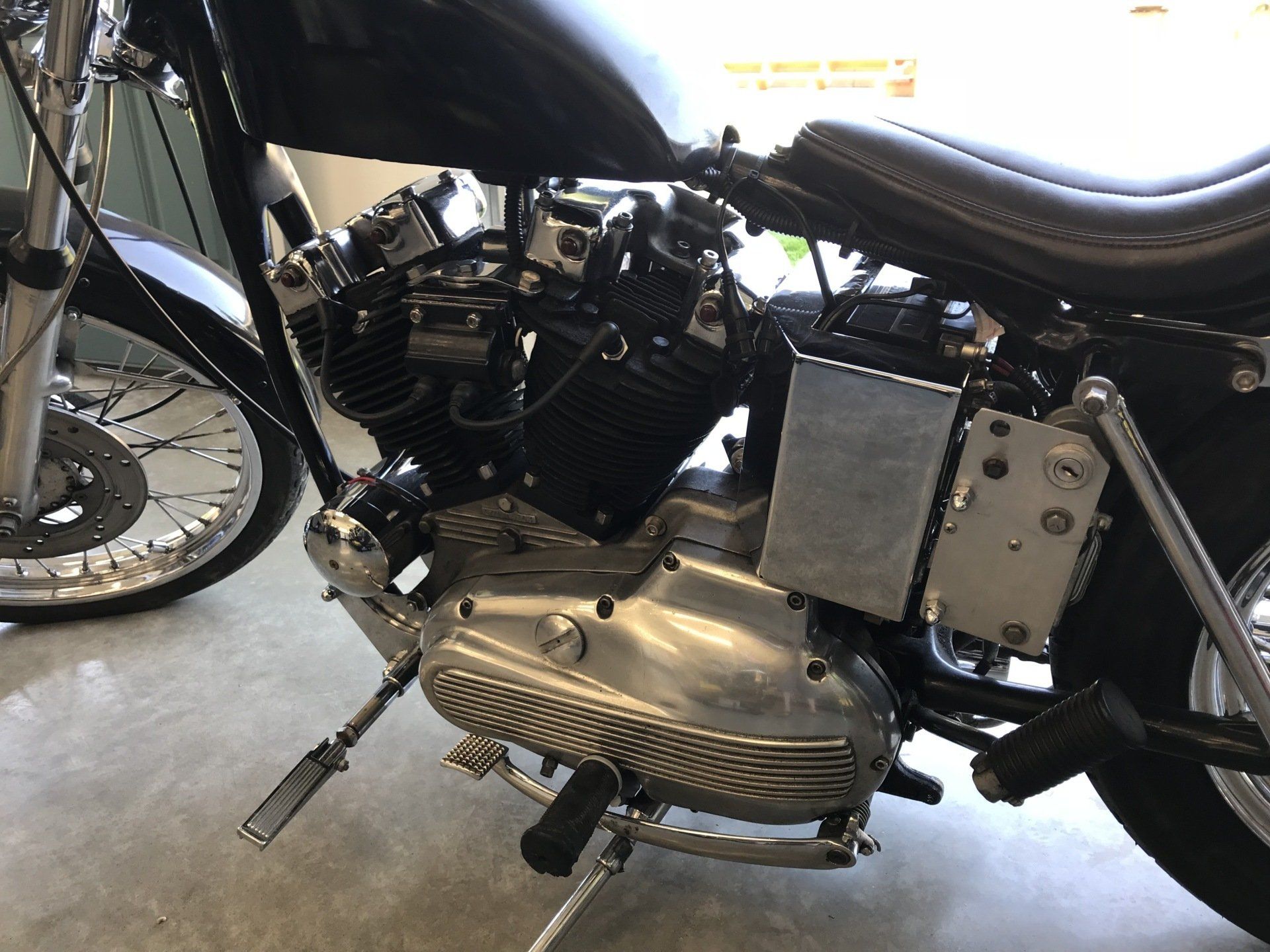 A black and silver motorcycle is parked in a garage