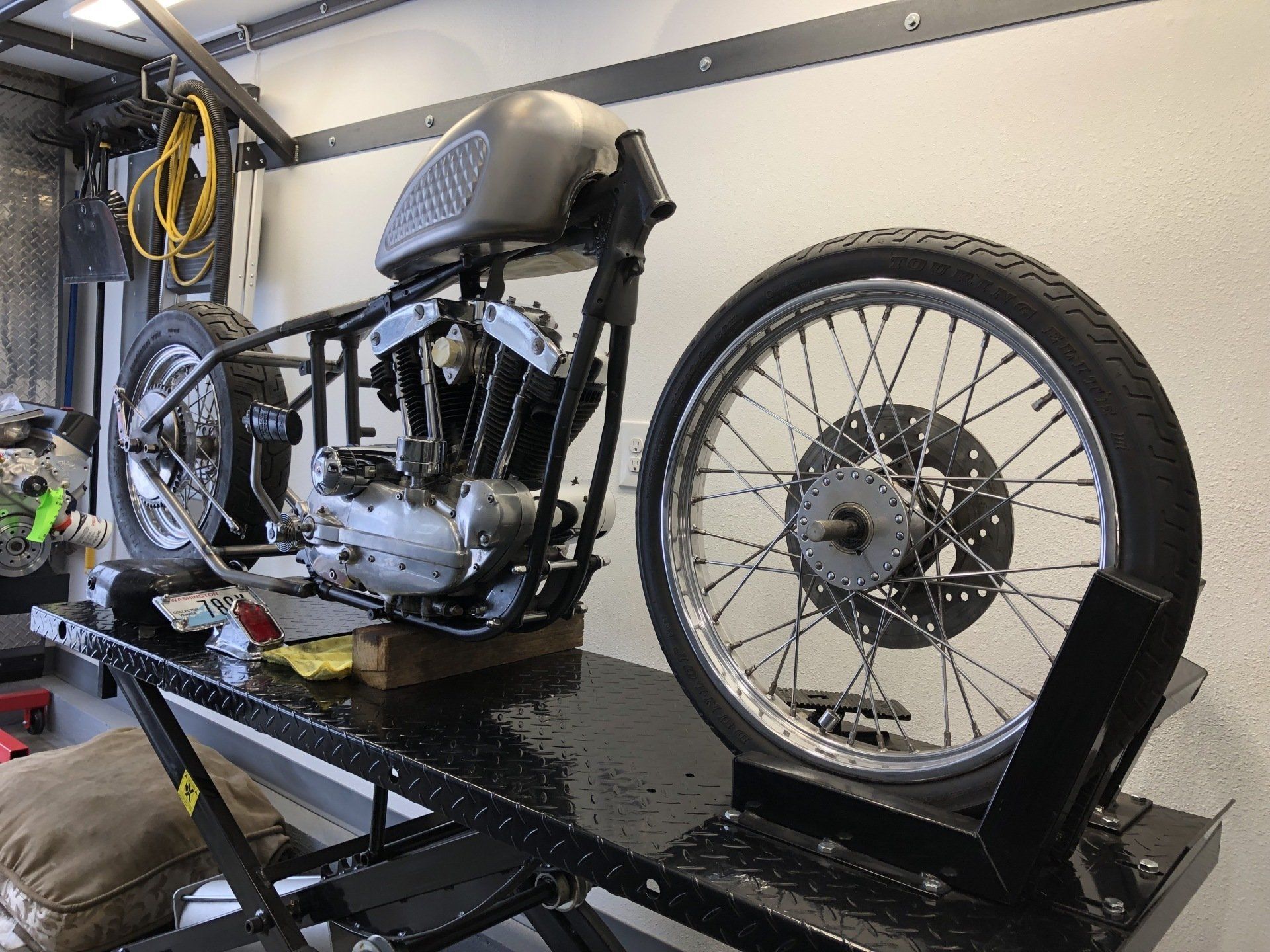 A motorcycle is sitting on a lift in a garage.