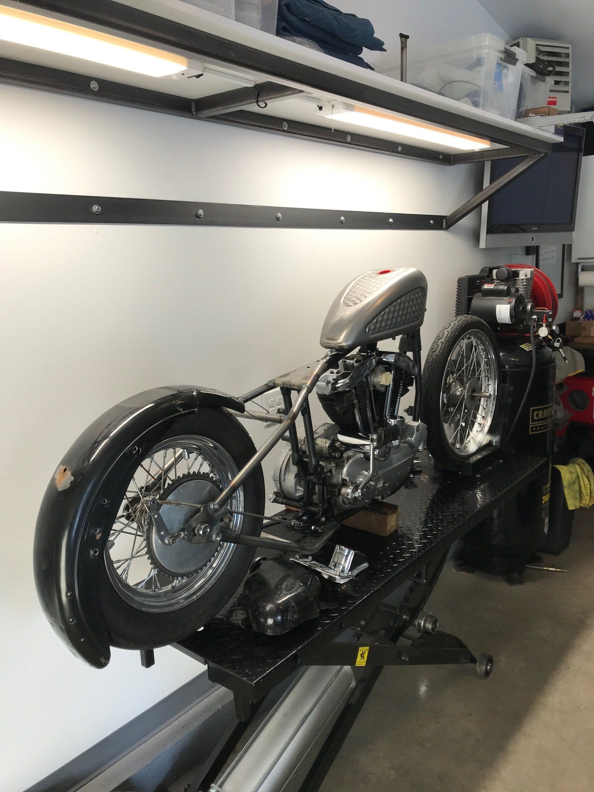 A motorcycle is sitting on a lift in a garage