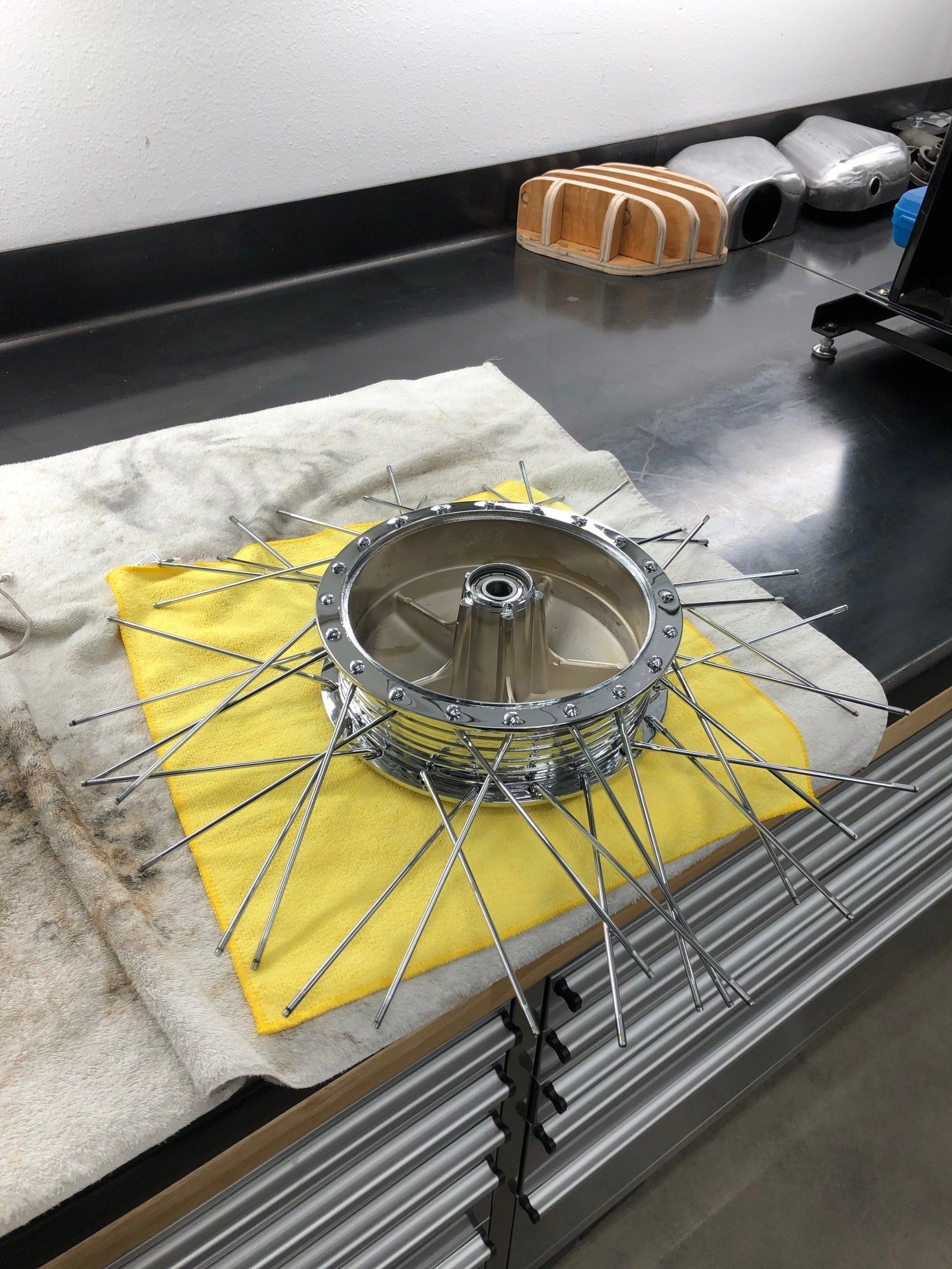 A metal object is sitting on a yellow cloth on a table.