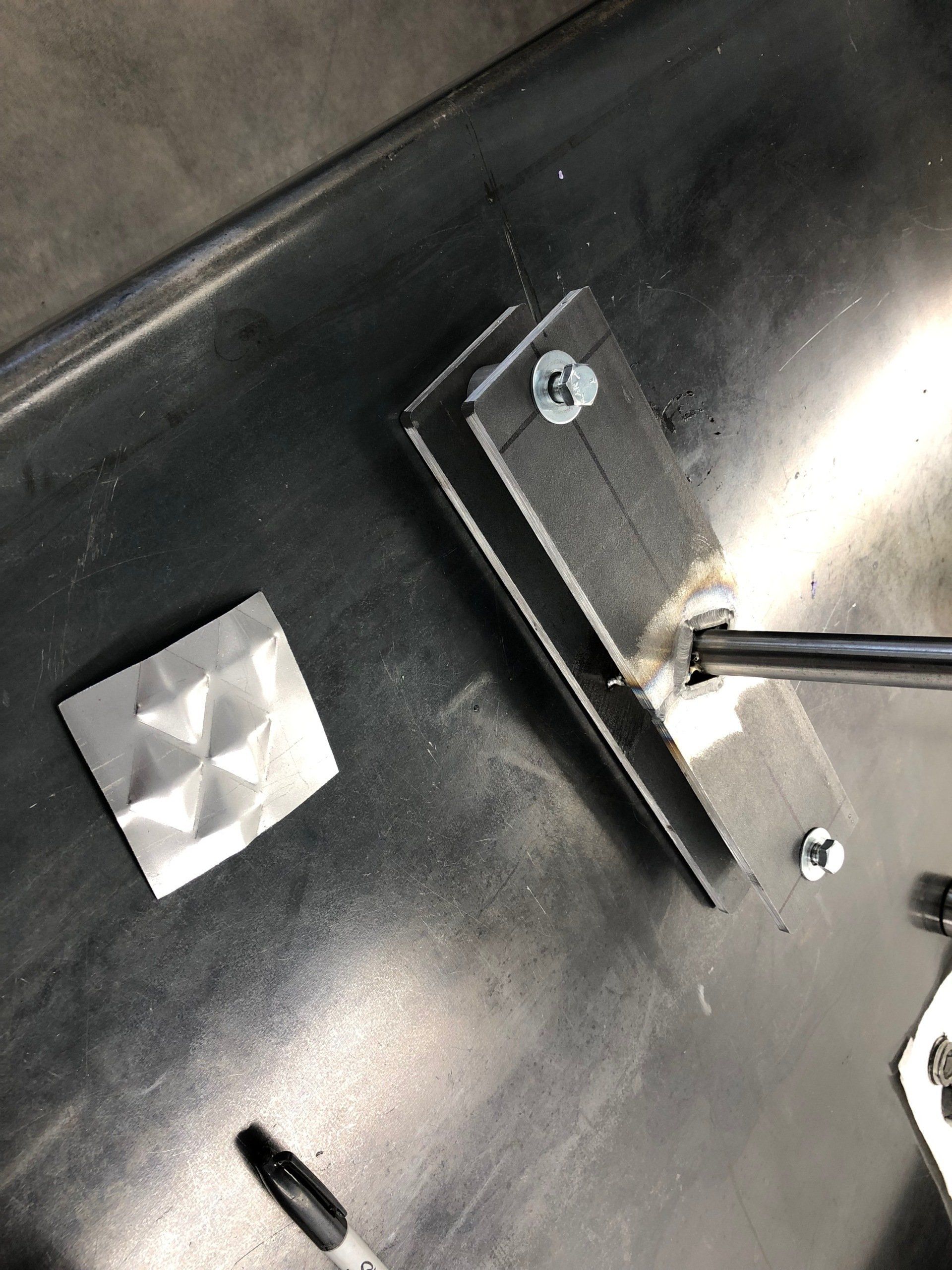 A piece of metal with a screw in it