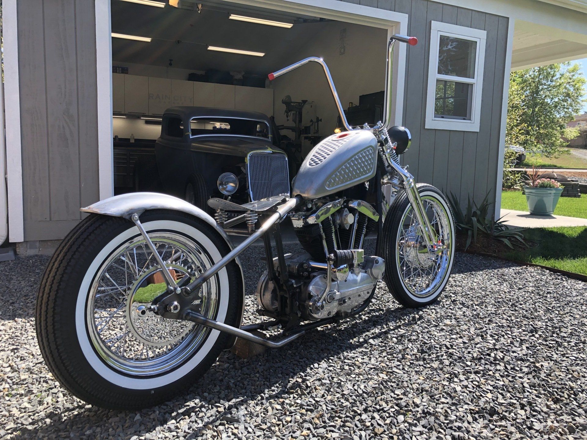 A motorcycle is parked in front of a garage.