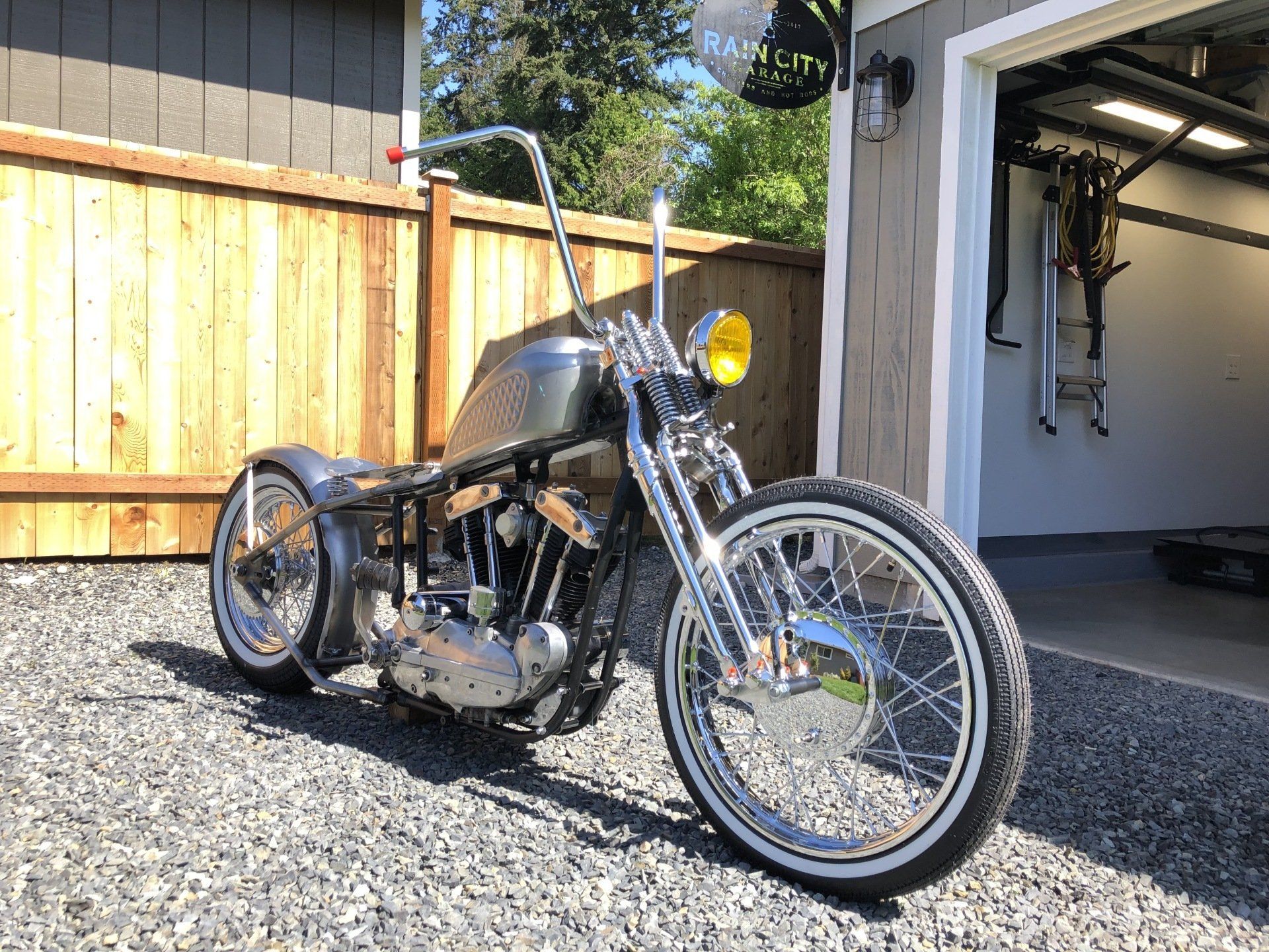 A motorcycle is parked in front of a garage.