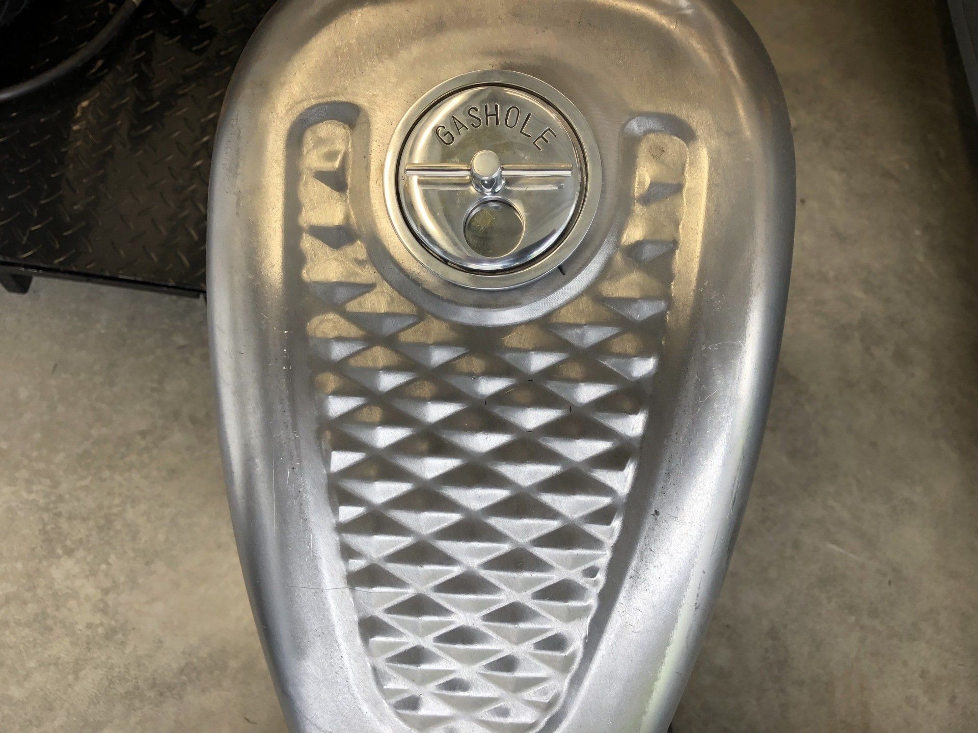 A close up of a motorcycle fuel tank with a lock on it.