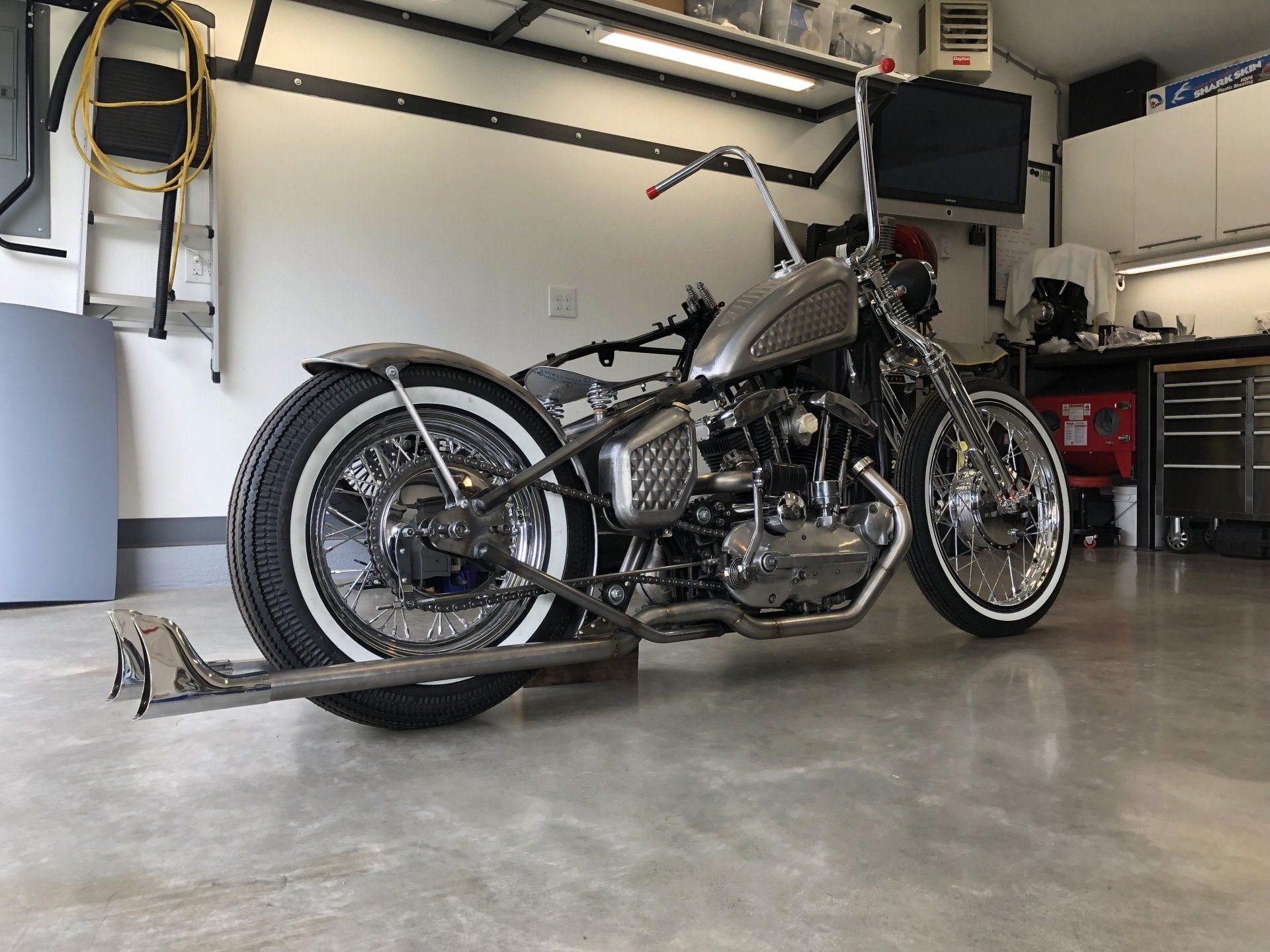 A motorcycle is parked in a garage with a trailer attached to it.
