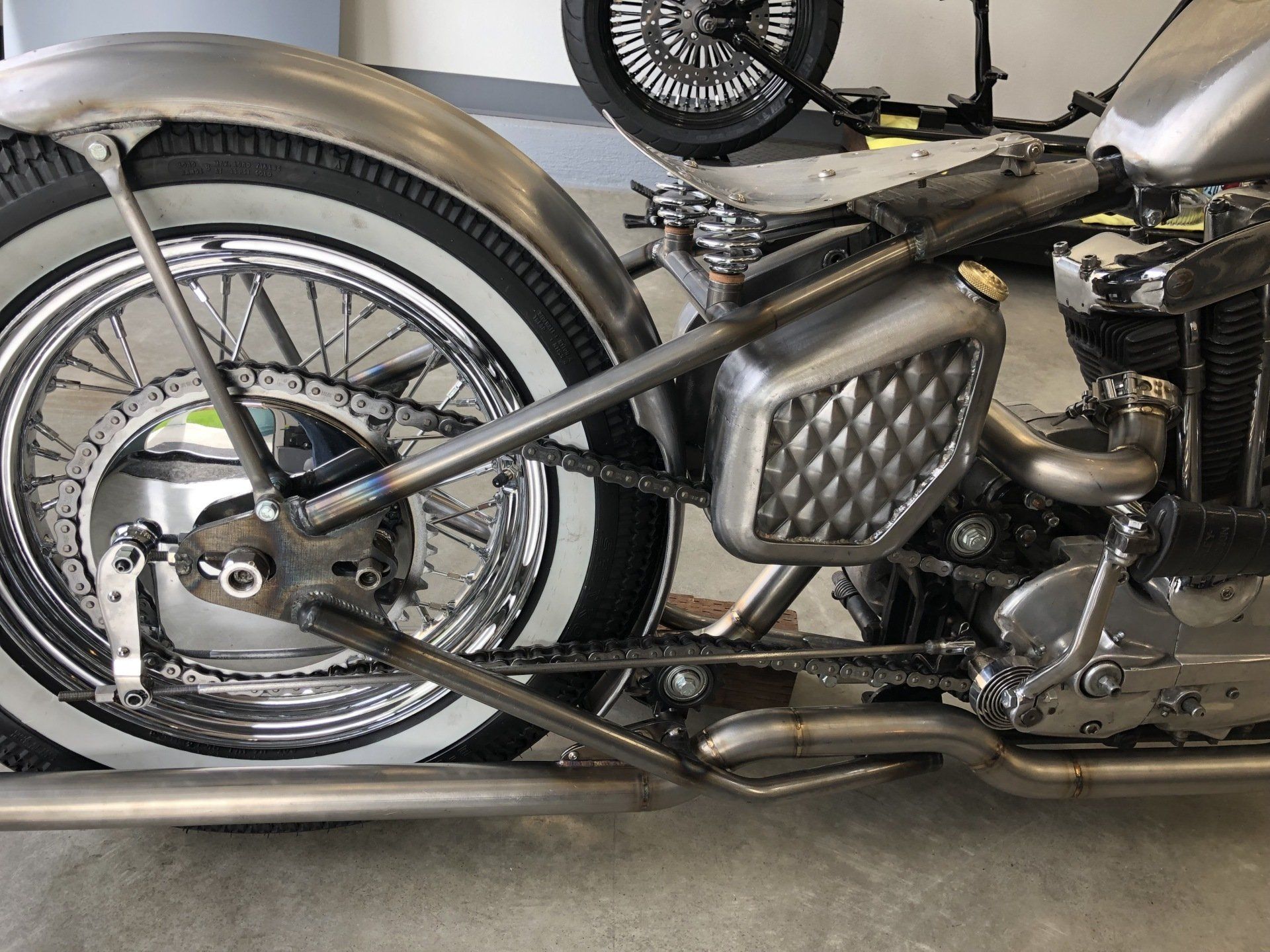 A motorcycle with white tires is parked in a garage.