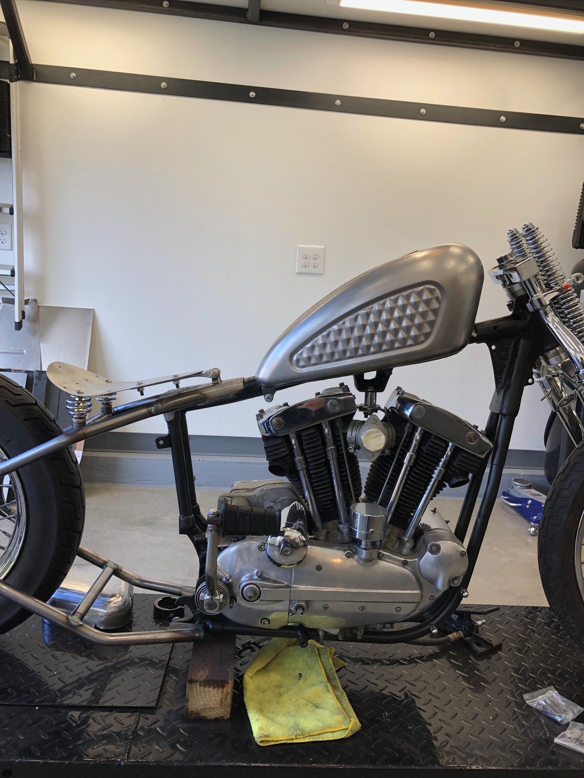 A motorcycle is sitting on a table in a garage.