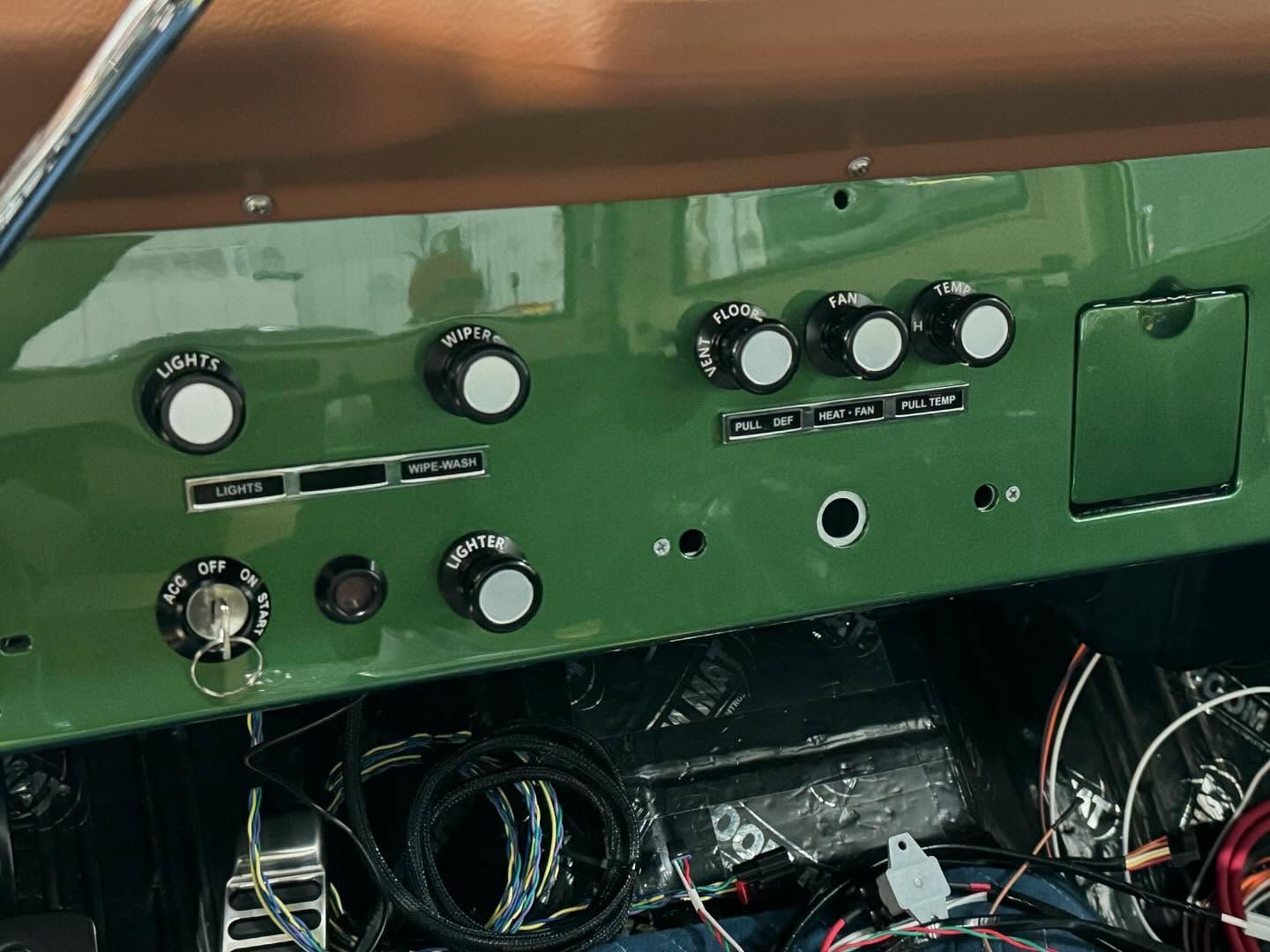 A green dashboard with a lot of buttons and wires