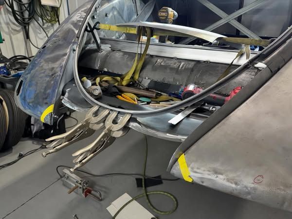 A piece of metal is being worked on in a garage