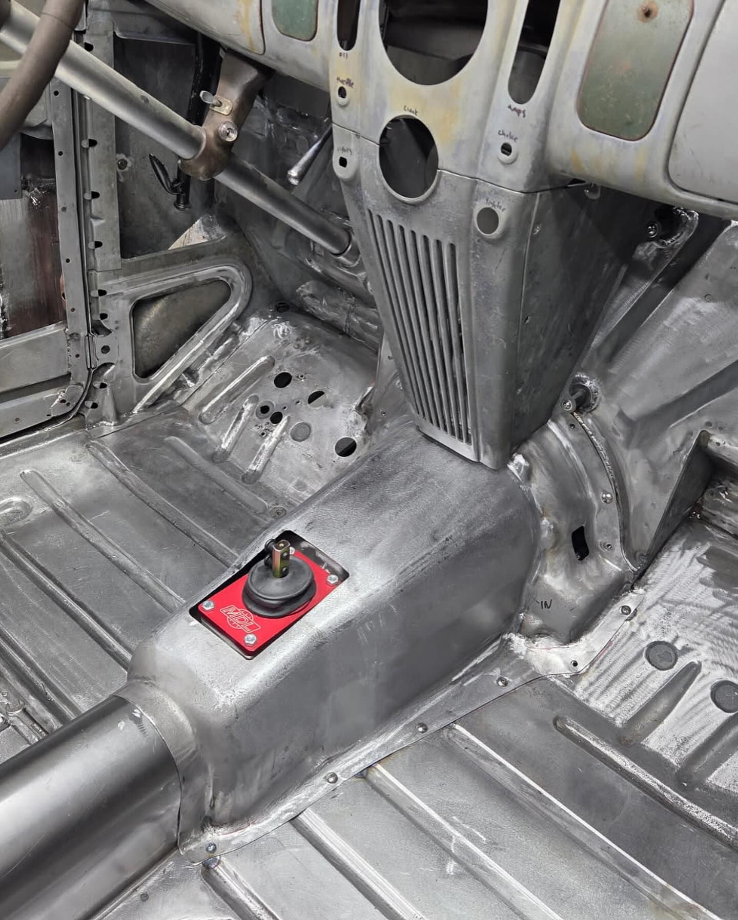 The inside of a car with a red button on the floor.