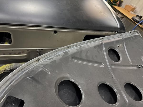 A close up of a car hood with holes in it