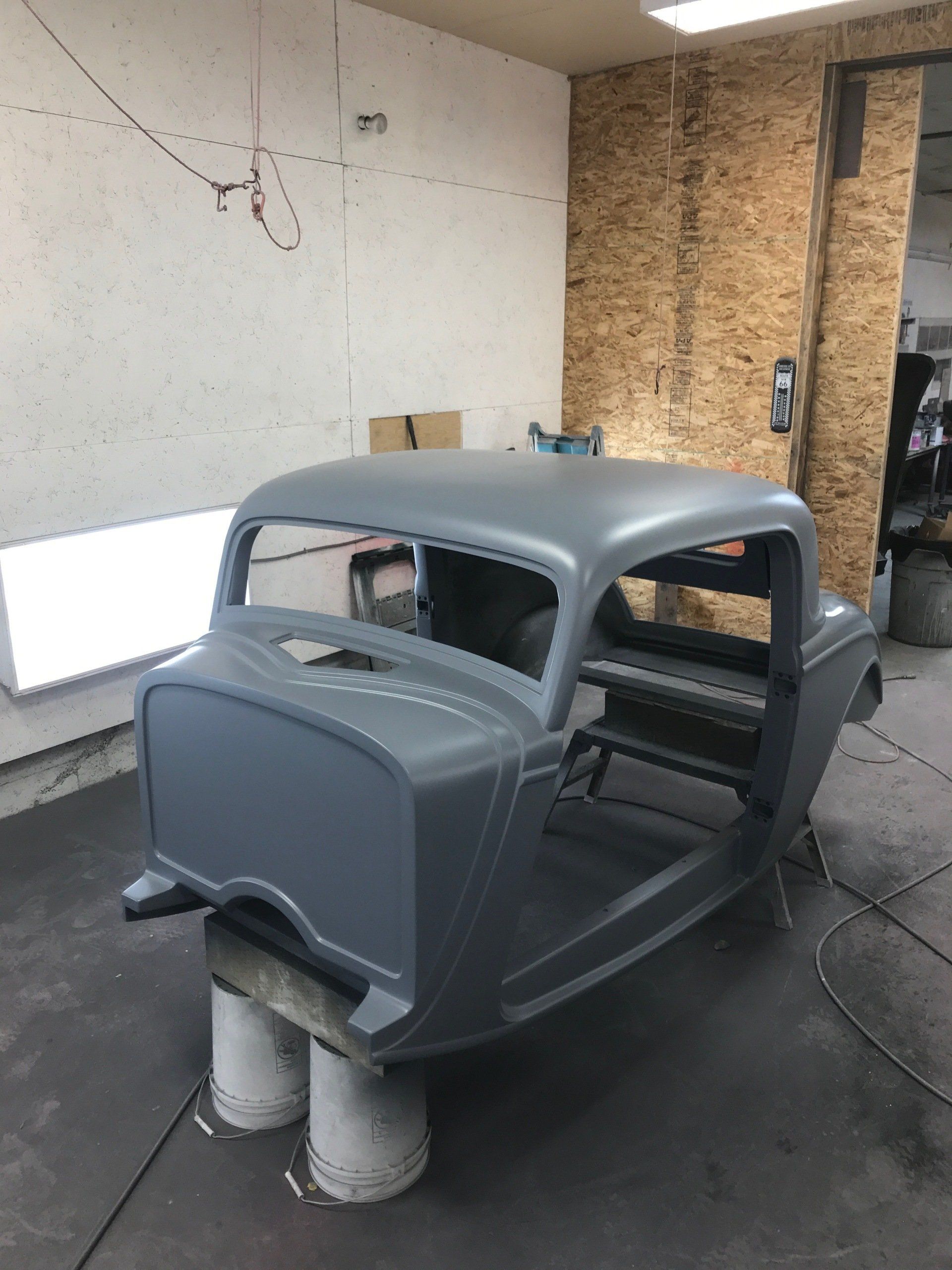 A car is being painted in a garage.