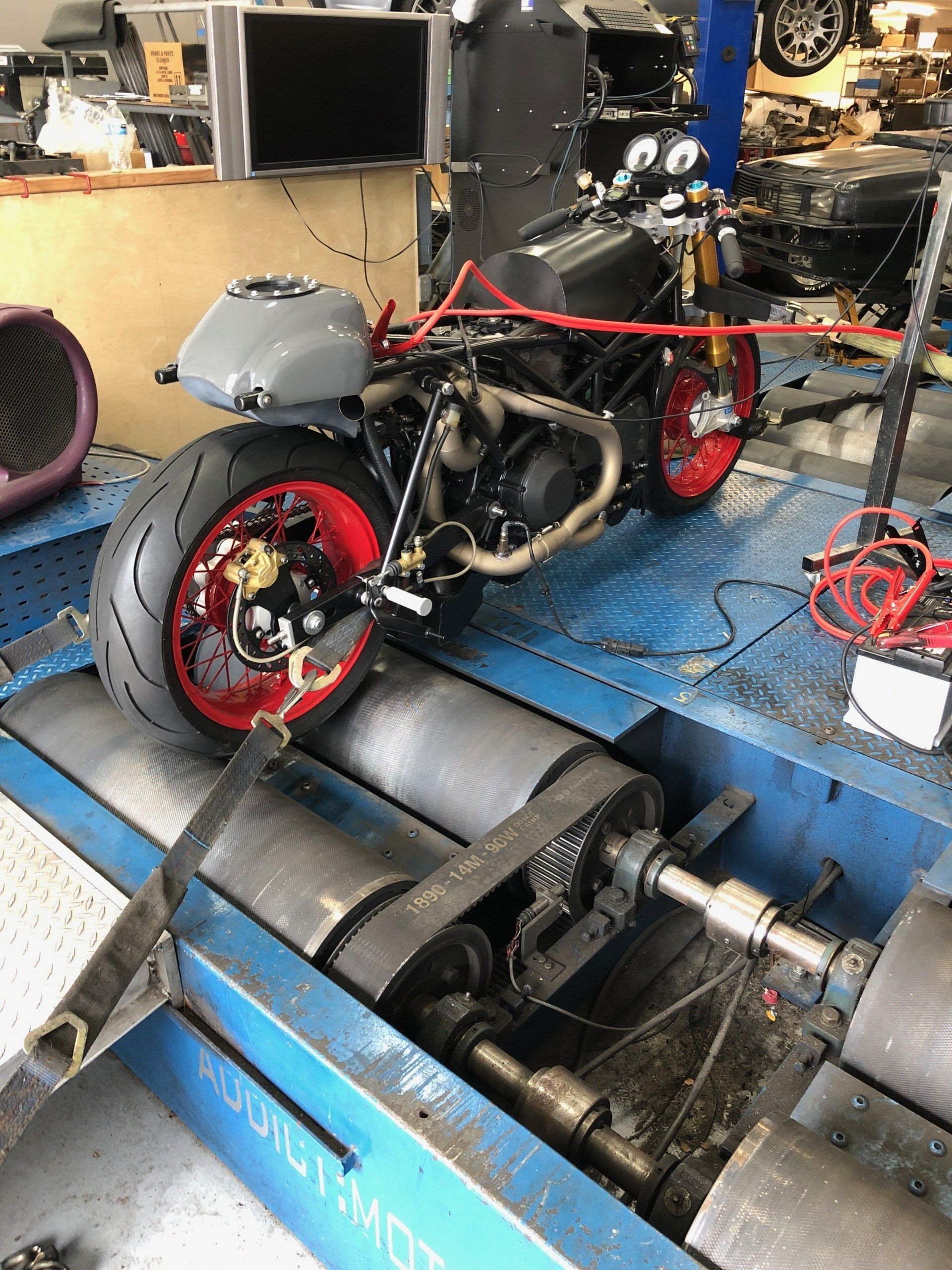 A motorcycle is sitting on top of a machine in a garage.