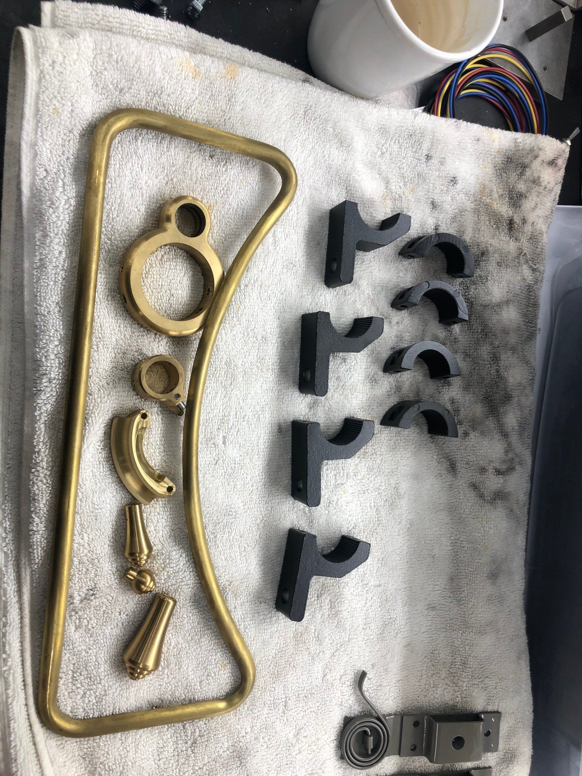 A bunch of metal parts are laying on a towel on a table.