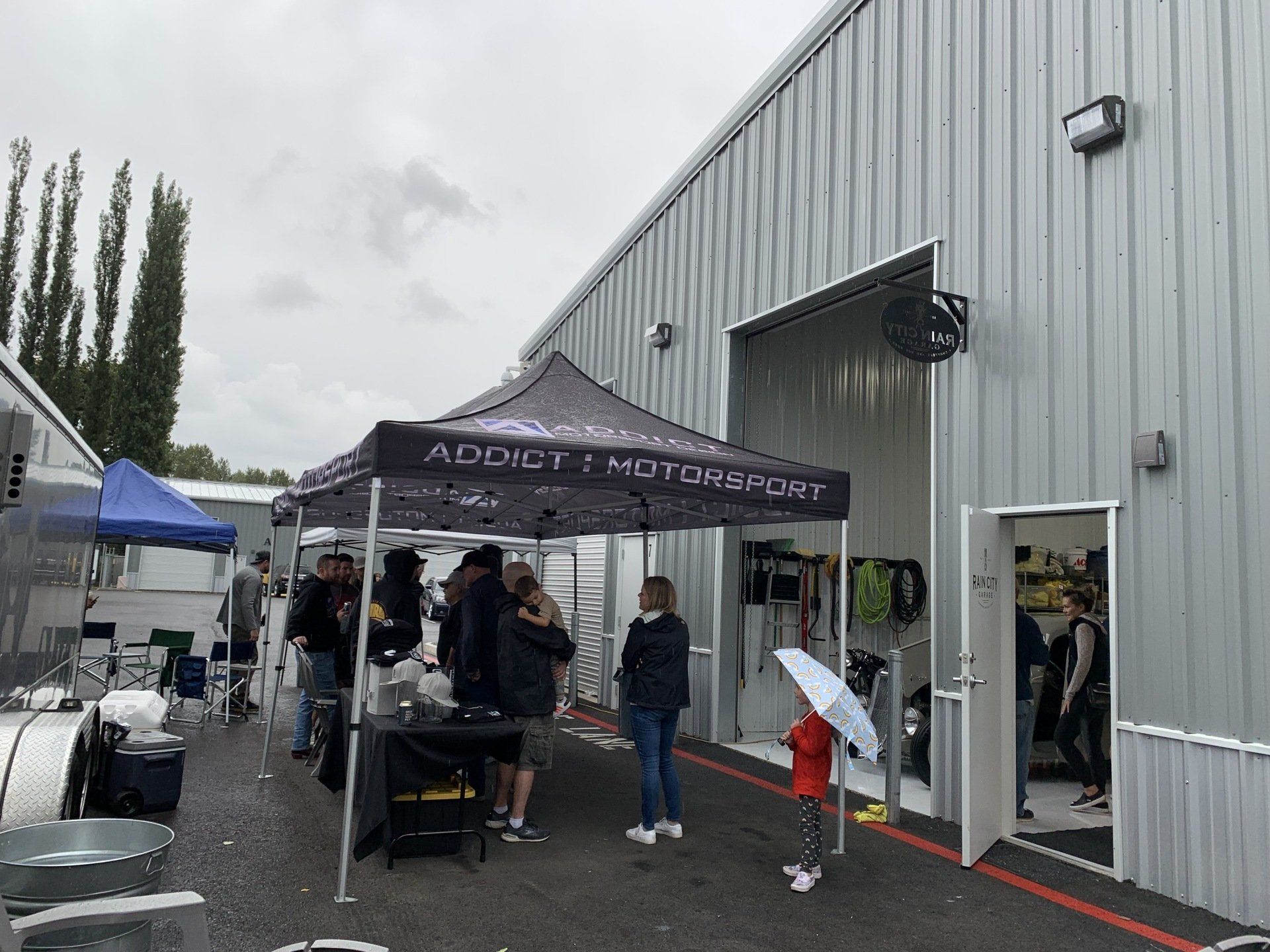 A group of people are standing under a tent in front of a building.
