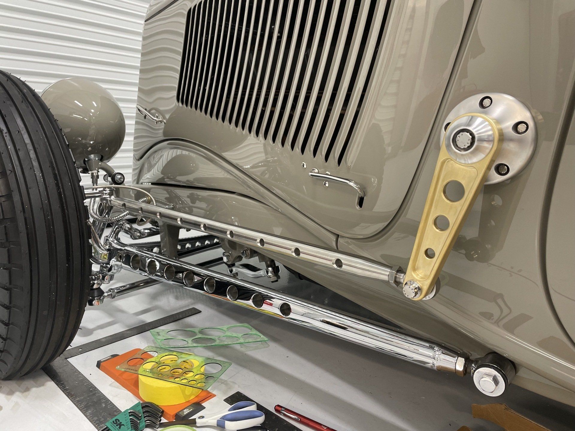 A close up of a car 's front end in a garage.