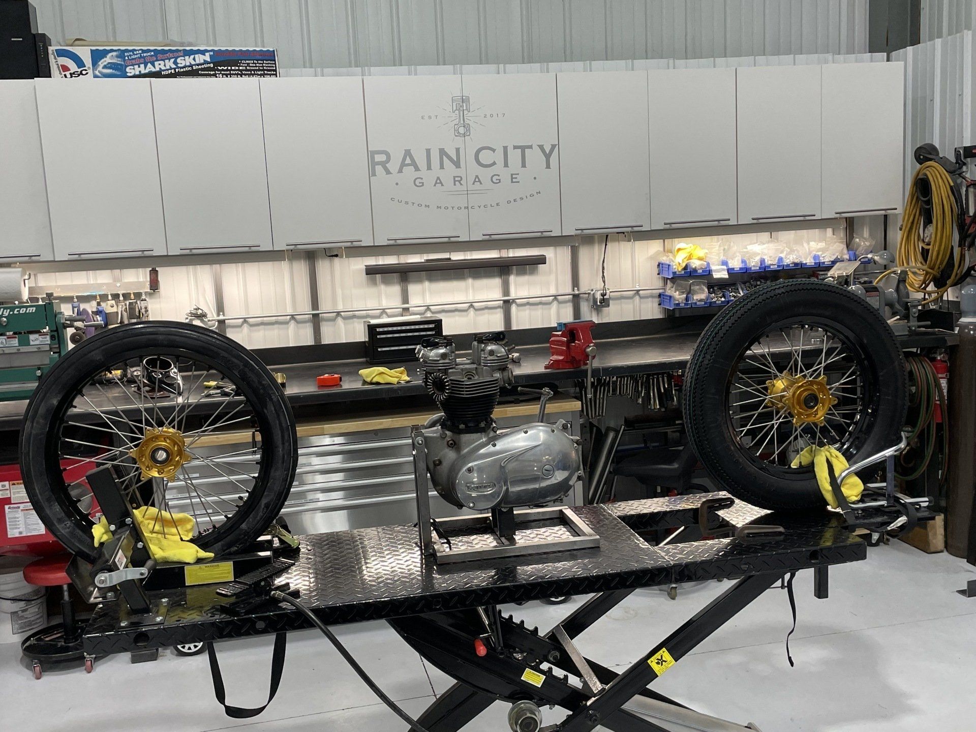 A motorcycle is sitting on a lift in a rain city garage