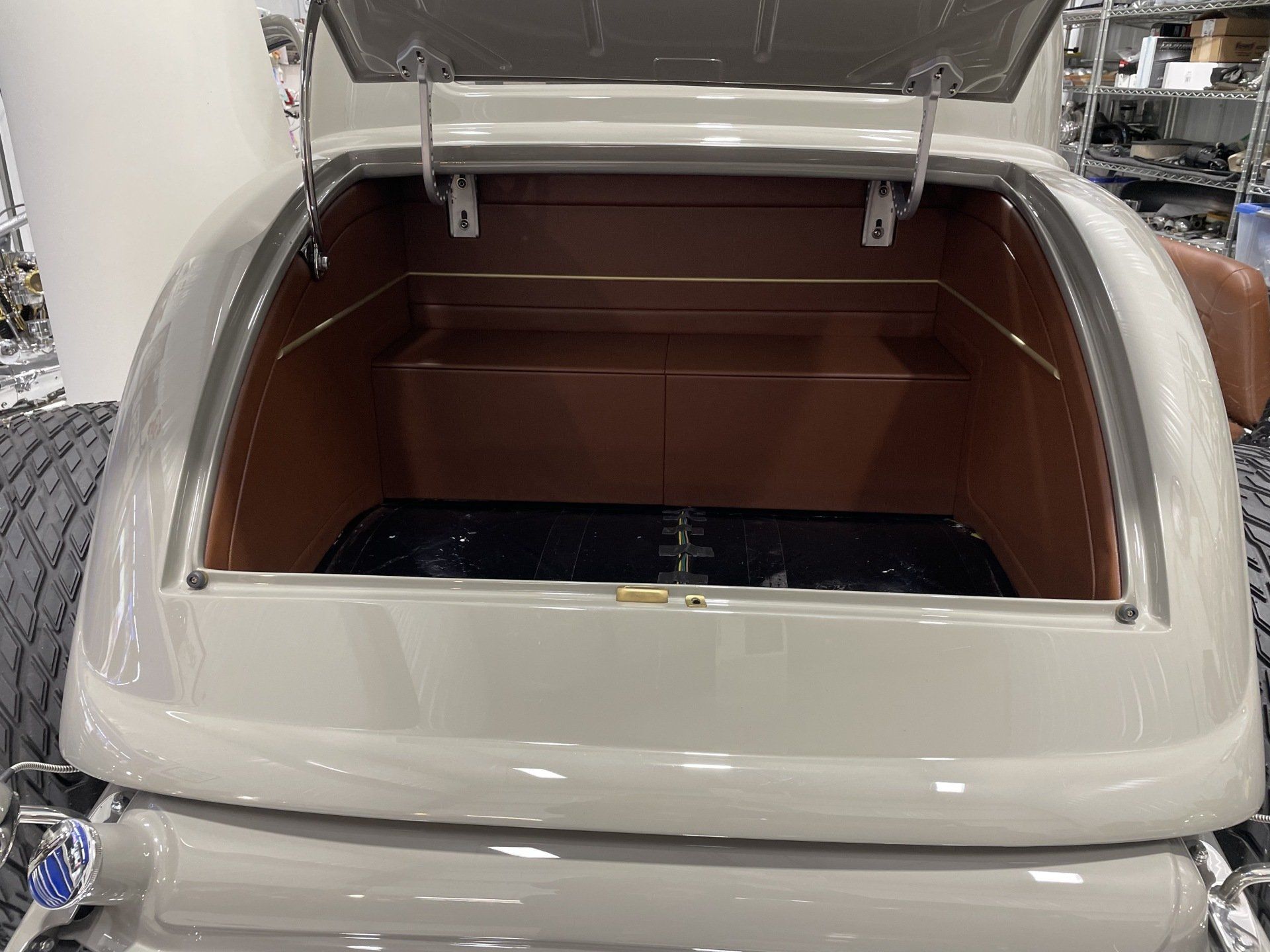 The back of a white car with the trunk open.