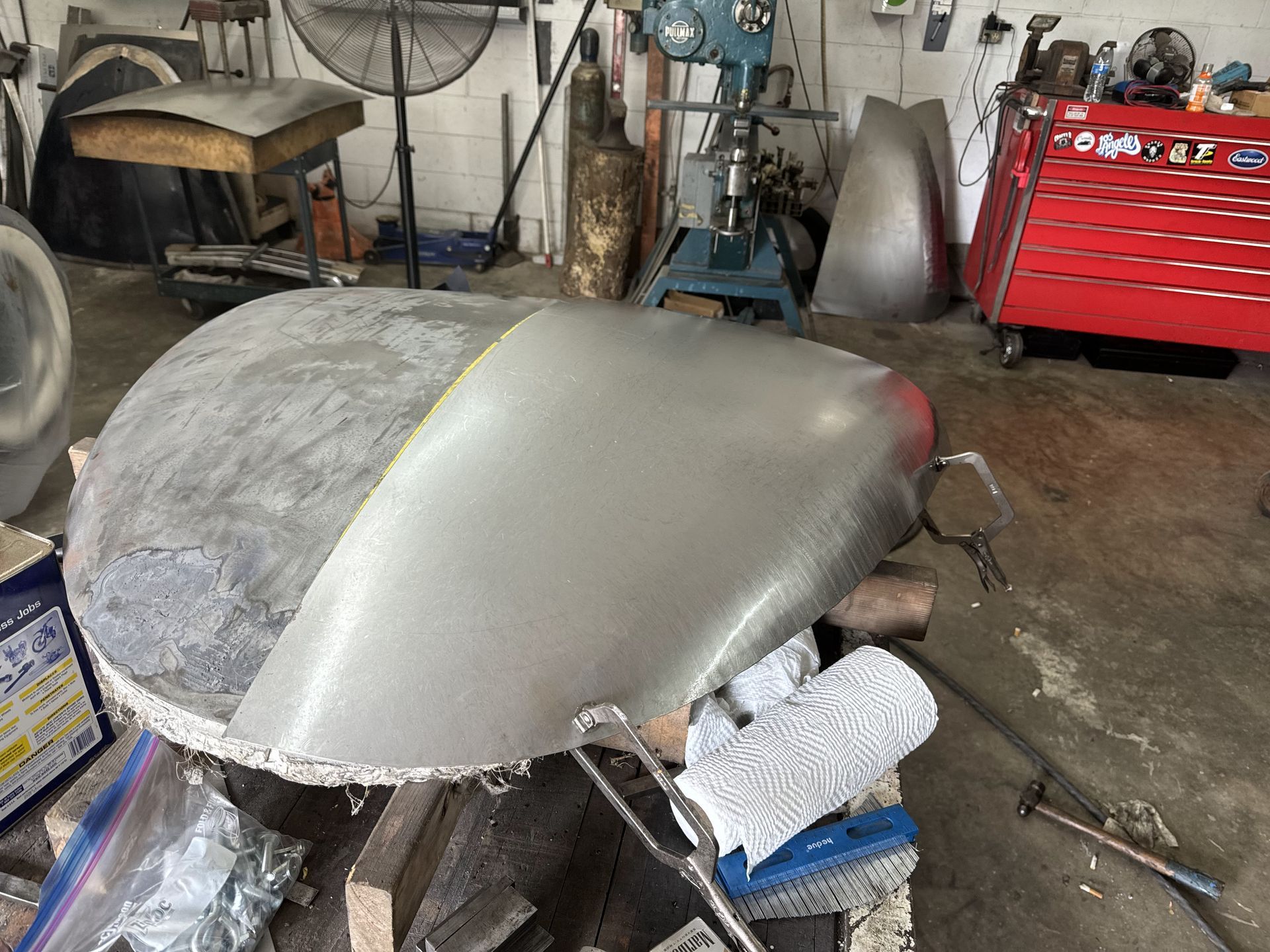 A large piece of metal is sitting on top of a wooden table in a garage.