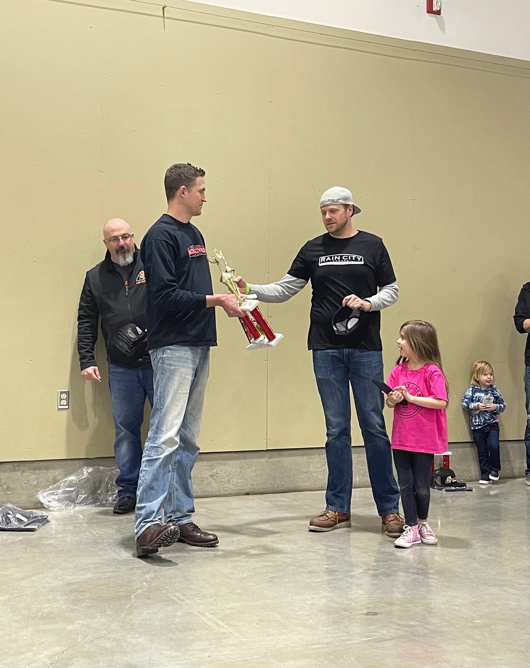 A group of men and a little girl are standing in a room.