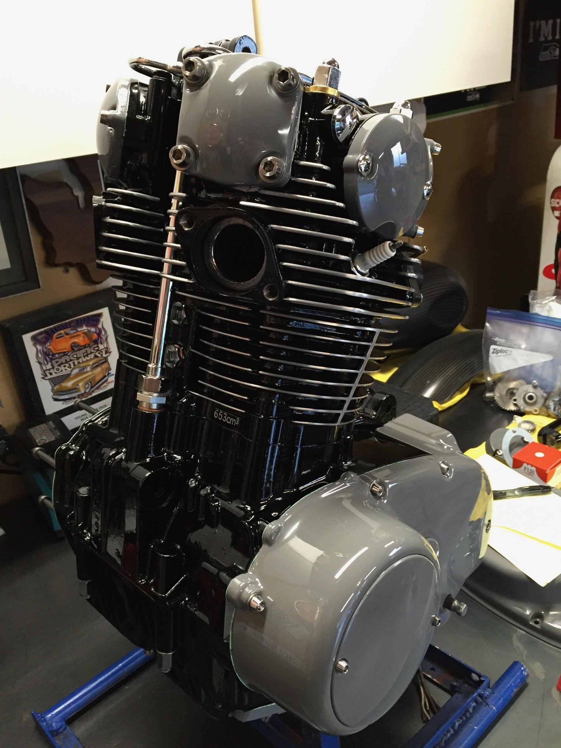 A black motorcycle engine is sitting on a blue stand