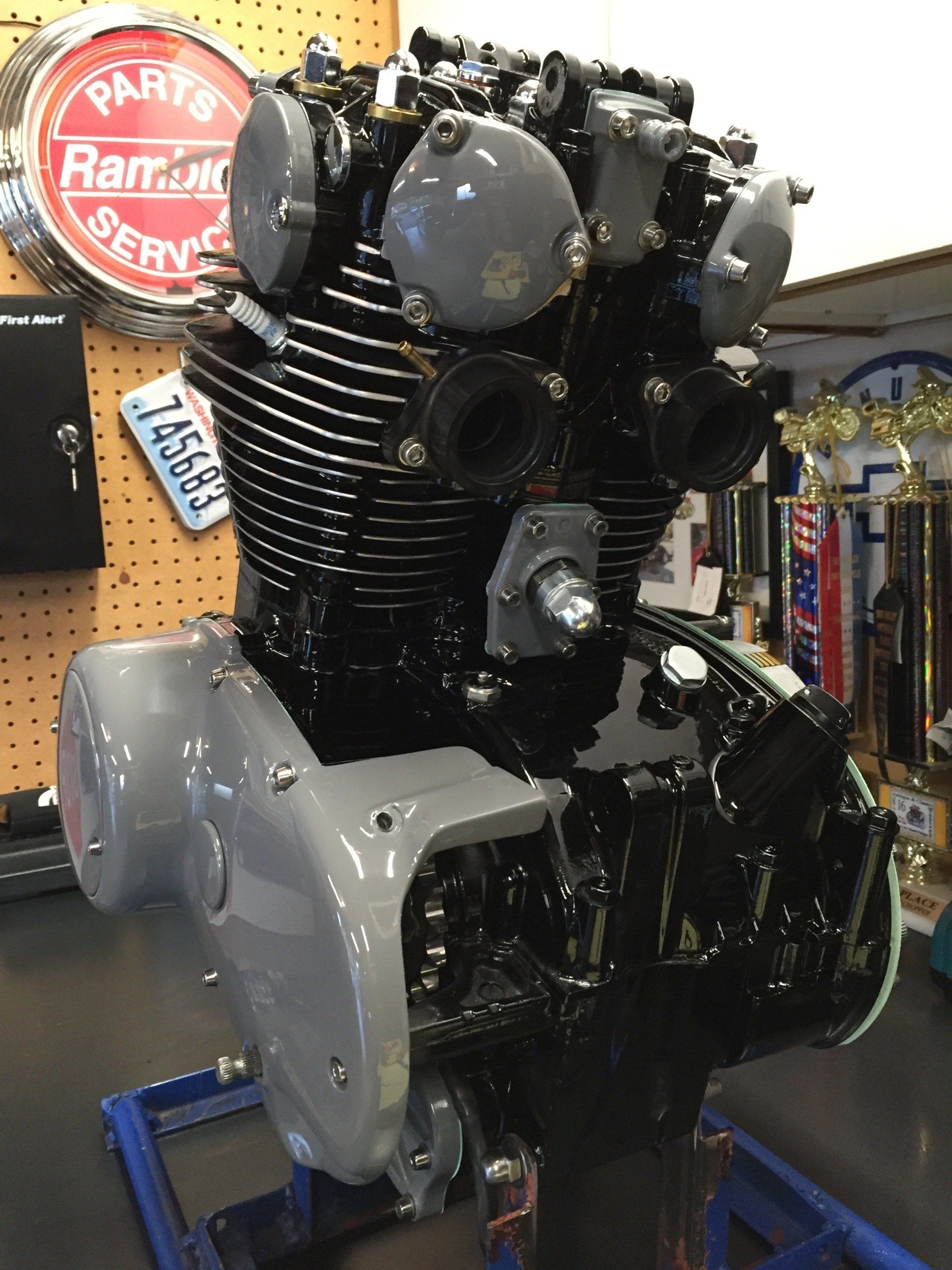 A motorcycle engine is sitting on a table in a garage.