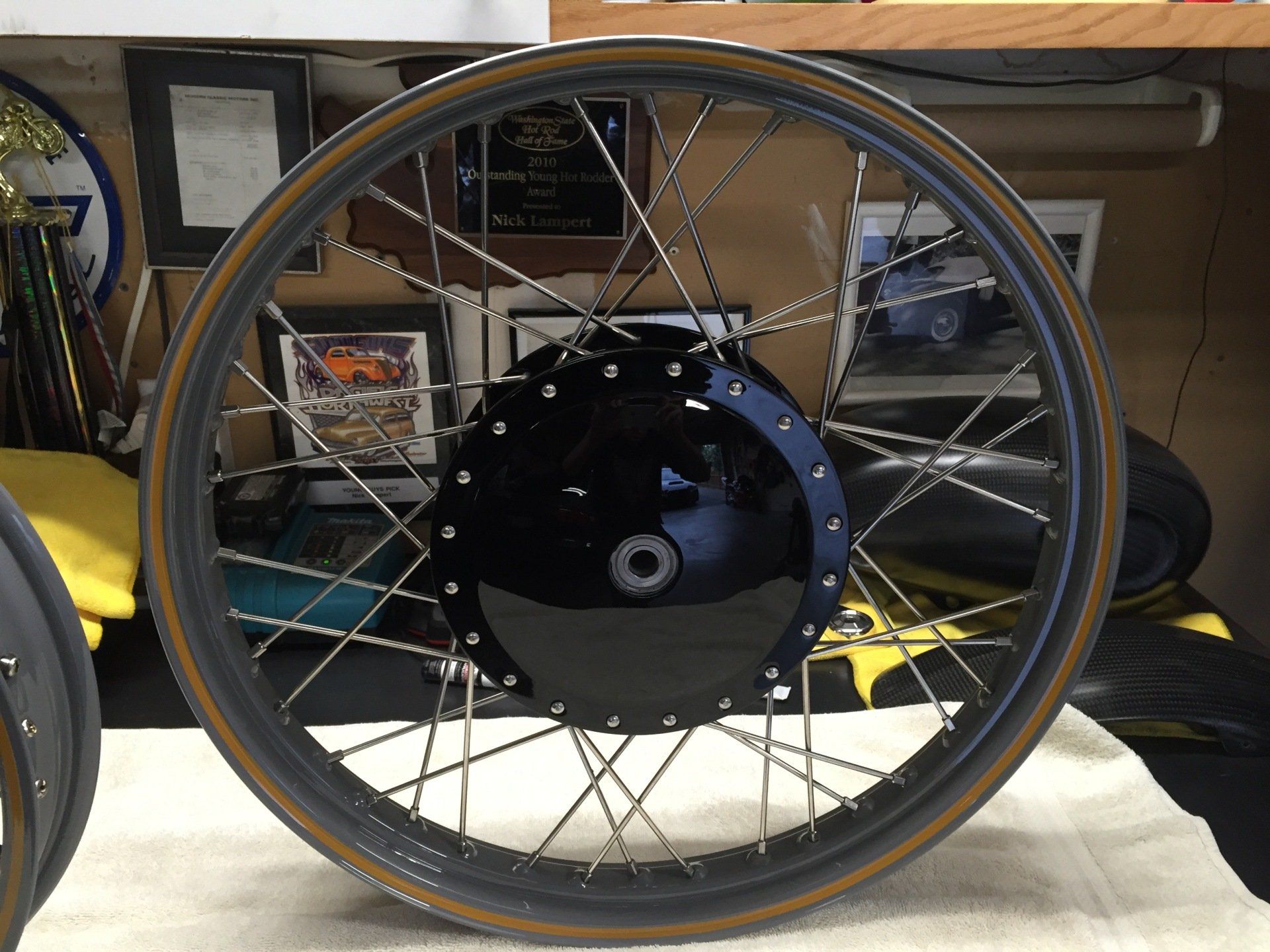 A close up of a motorcycle wheel with a plaque in the background